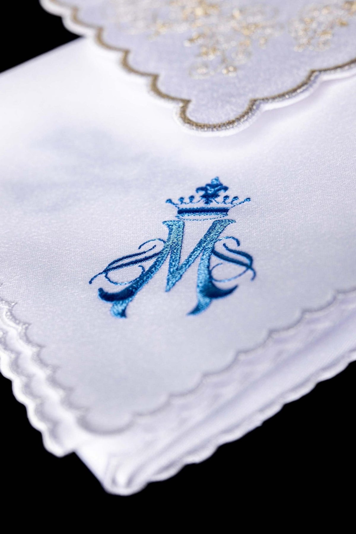 White altar linen set close-up showing blue crowned Marian motif and scalloped edge