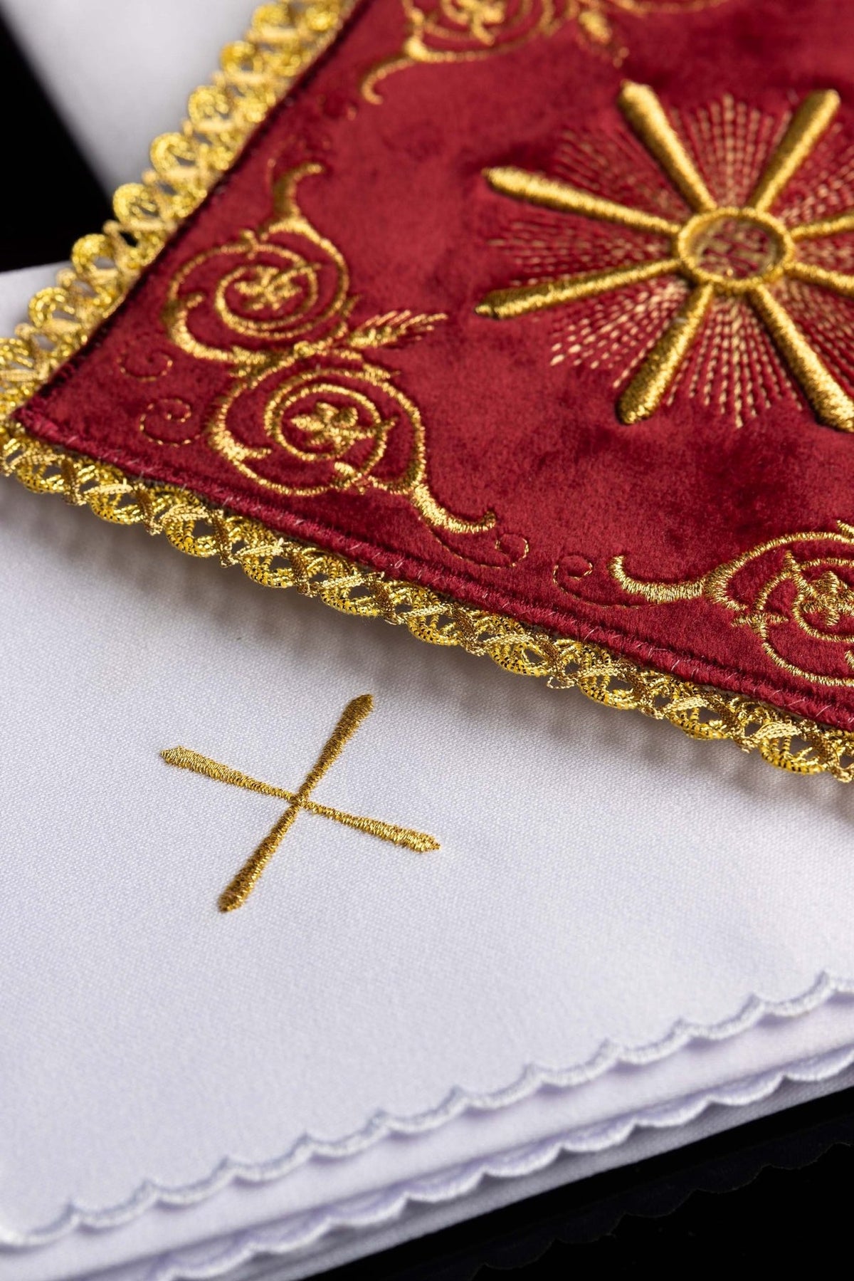 Close-up of red velvet chalice pall with gold embroidery and scalloped gold trim