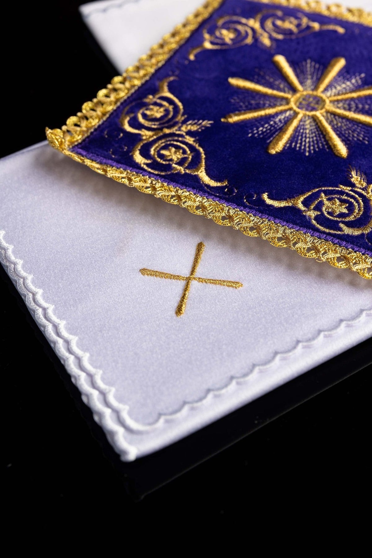 Purple velvet pall detail showing gold embroidery, ornate scrolls and scalloped gold trim