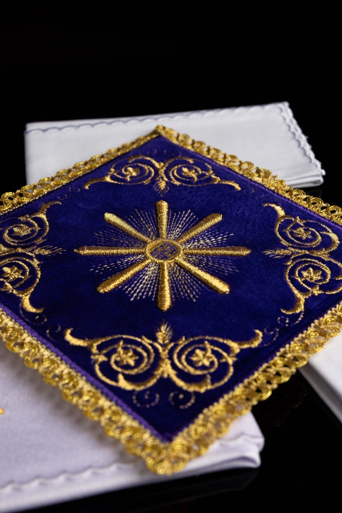 Purple velvet pall close-up with central gold embroidery and ornate scroll motifs