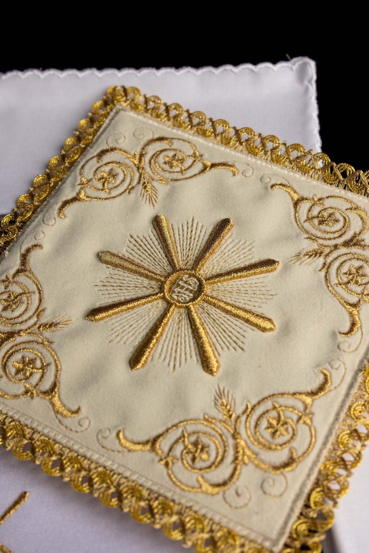 Altar linen set close-up showing ecru Eucharistic Sun embroidery and gold decorative border