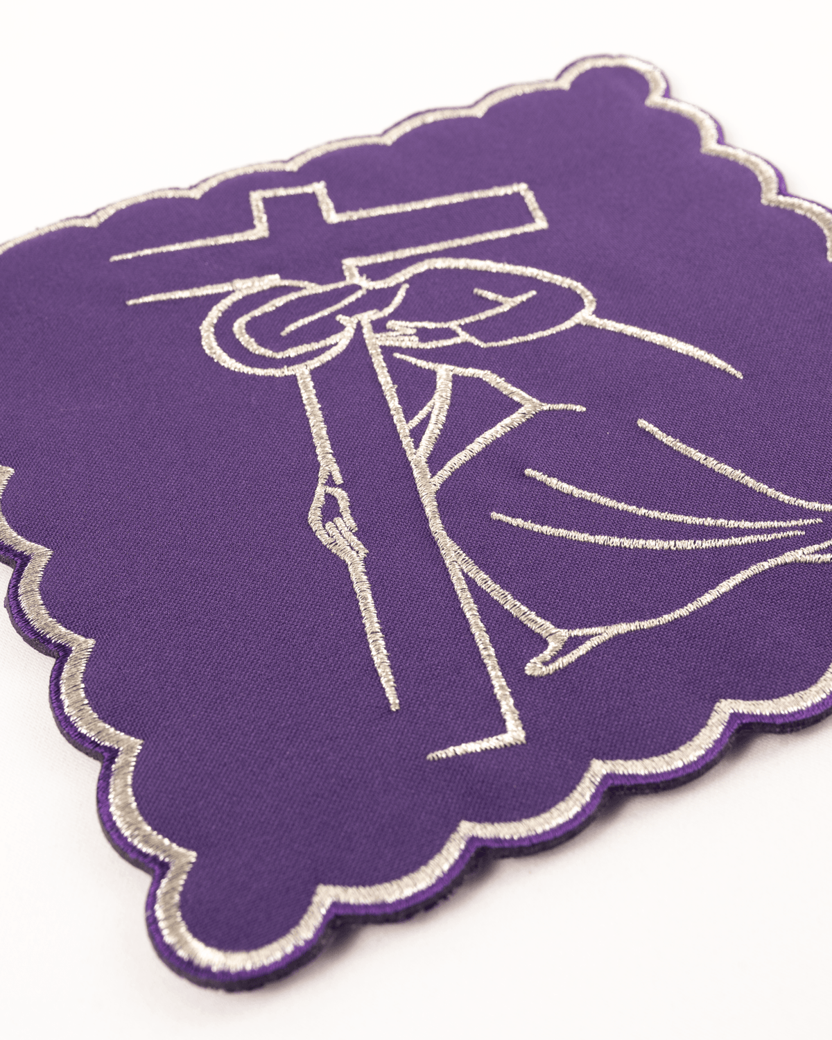 Altar linen set chalice pall close-up, purple fabric with embroidered silver Stations of the Cross motif