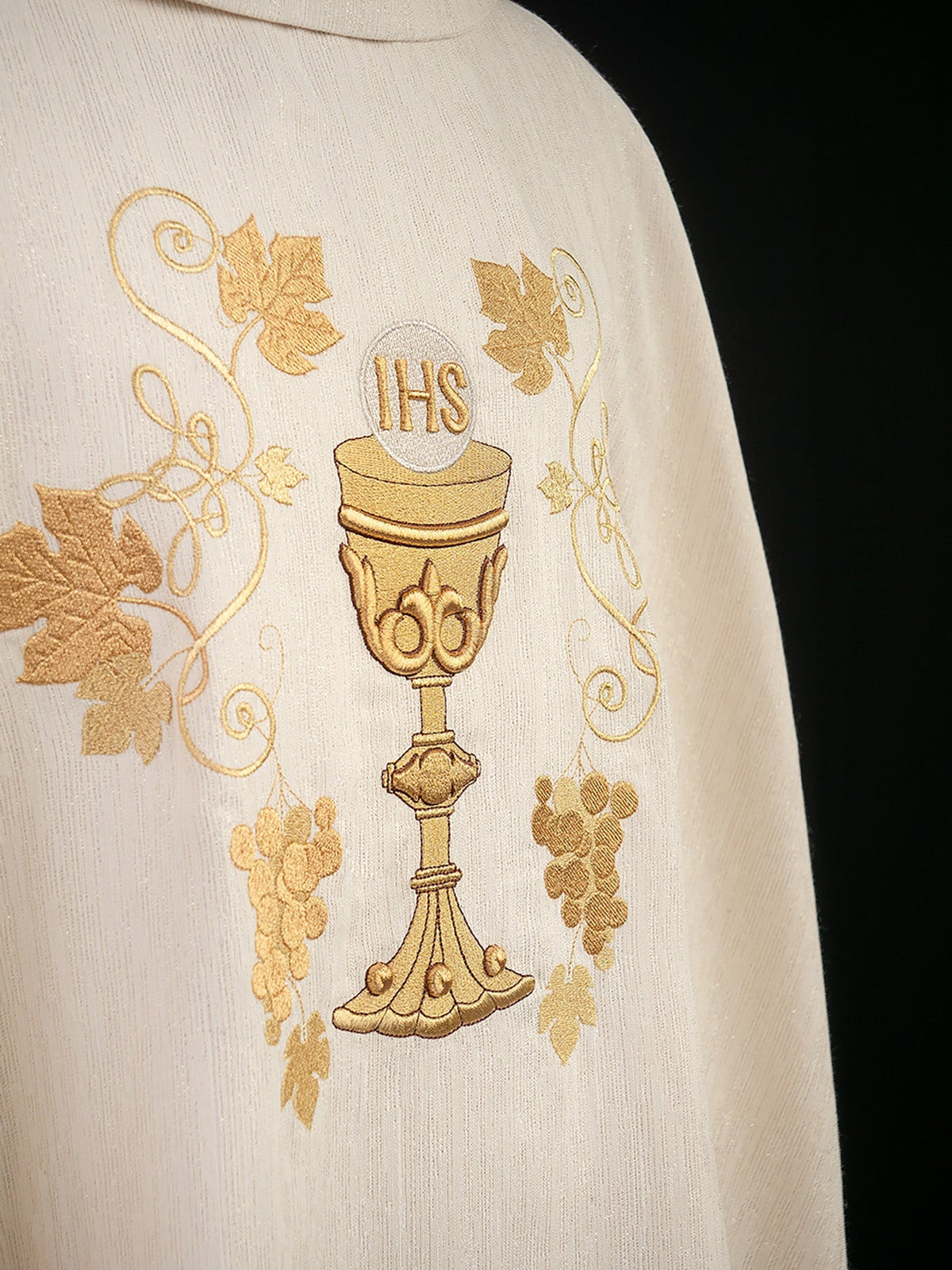 Embroidered chasuble close-up showing gold chalice, grapes and vine