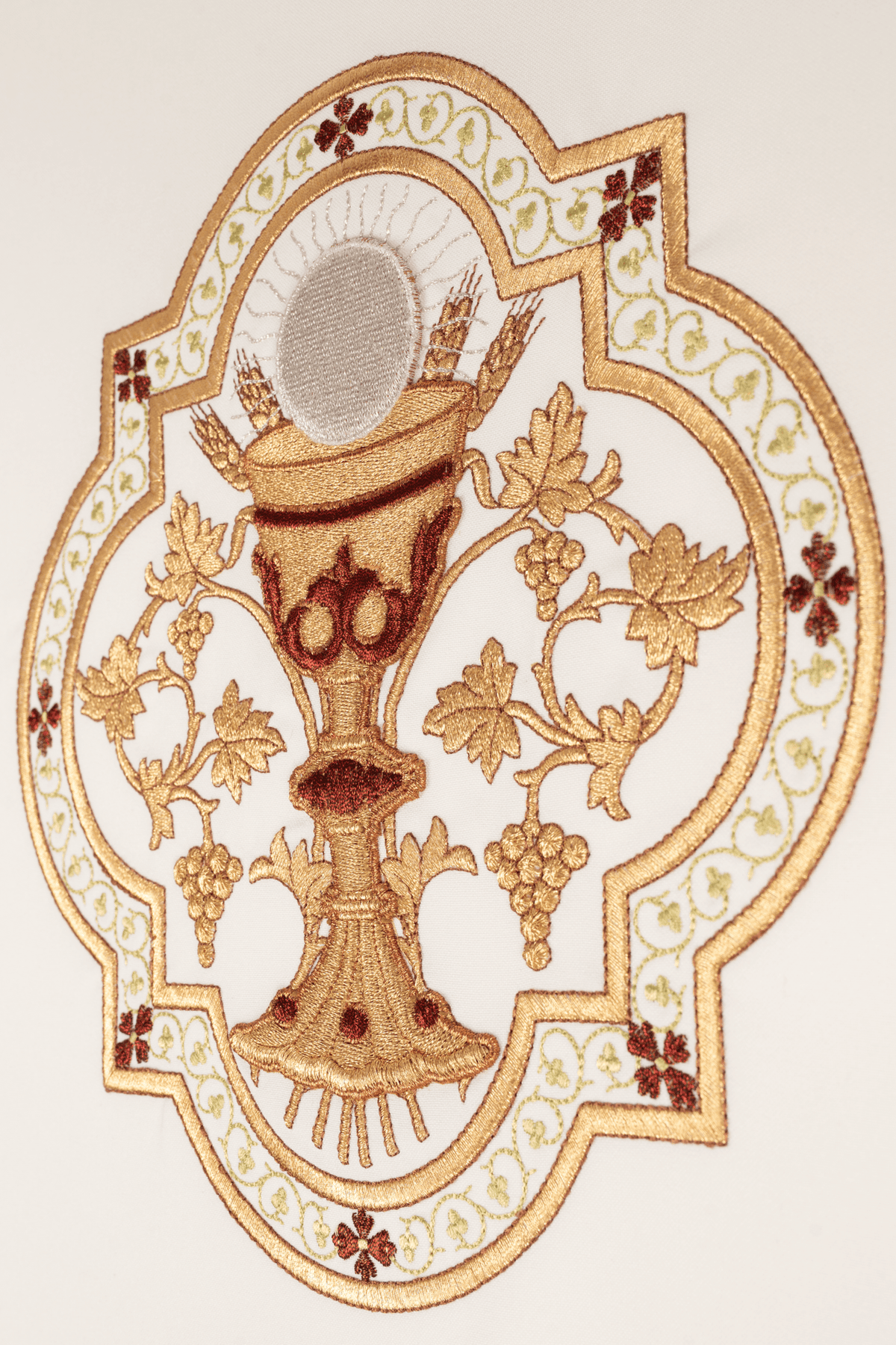 Chasuble close-up showing embroidered gold chalice, host, grapes and floral motifs