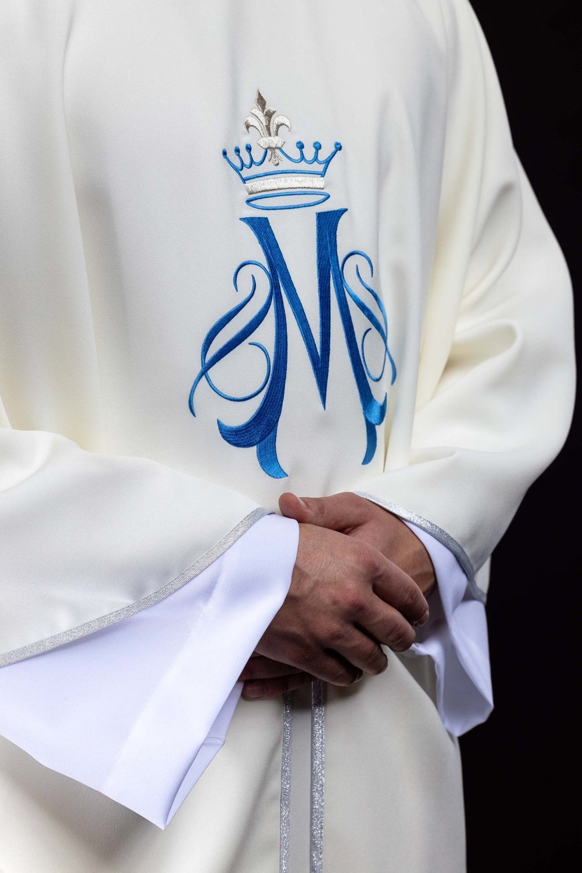 Marian chasuble detail showing blue Marian motif and silver trim on ecru fabric
