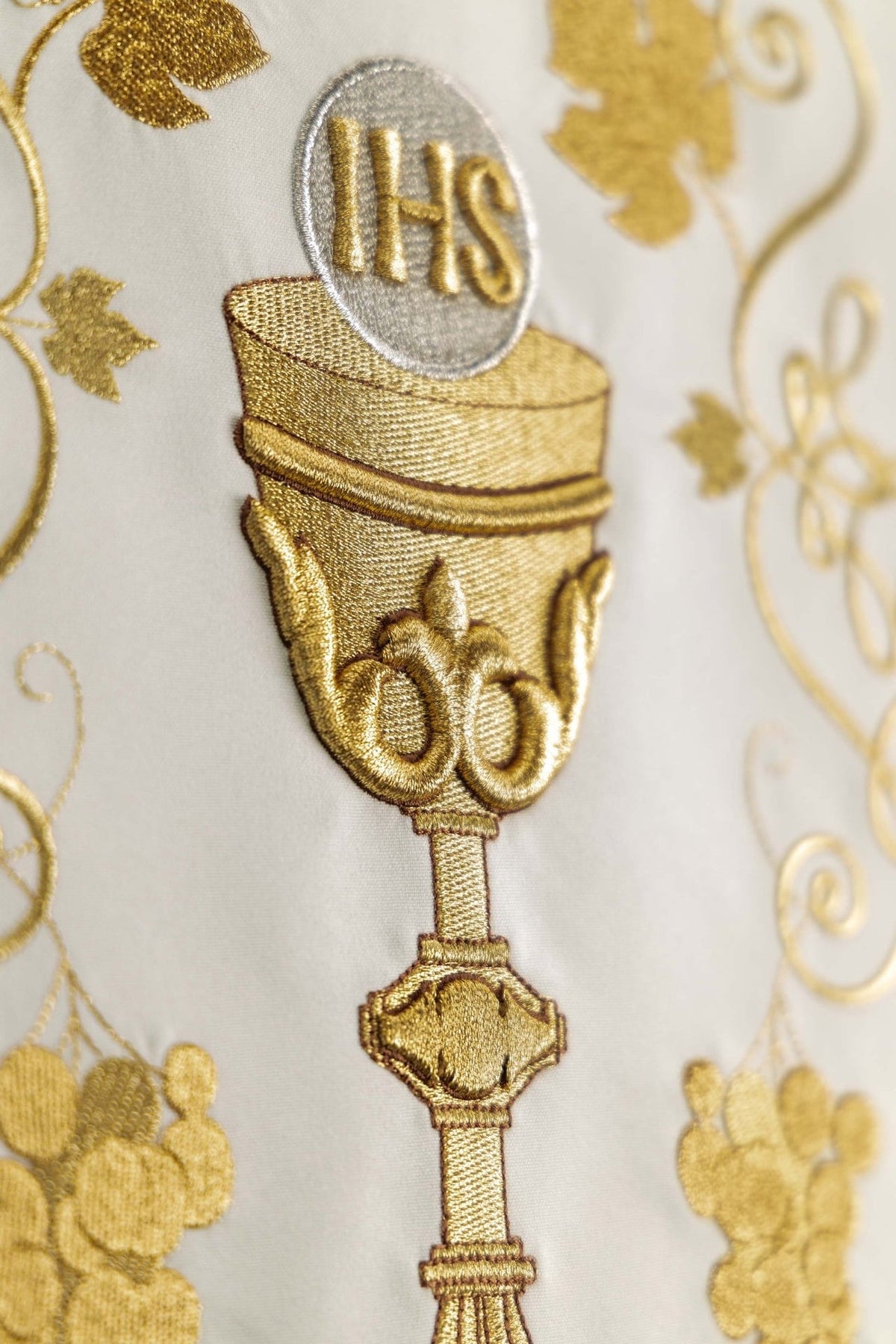 Church lectern cover close-up showing embroidered gold chalice and IHS monogram