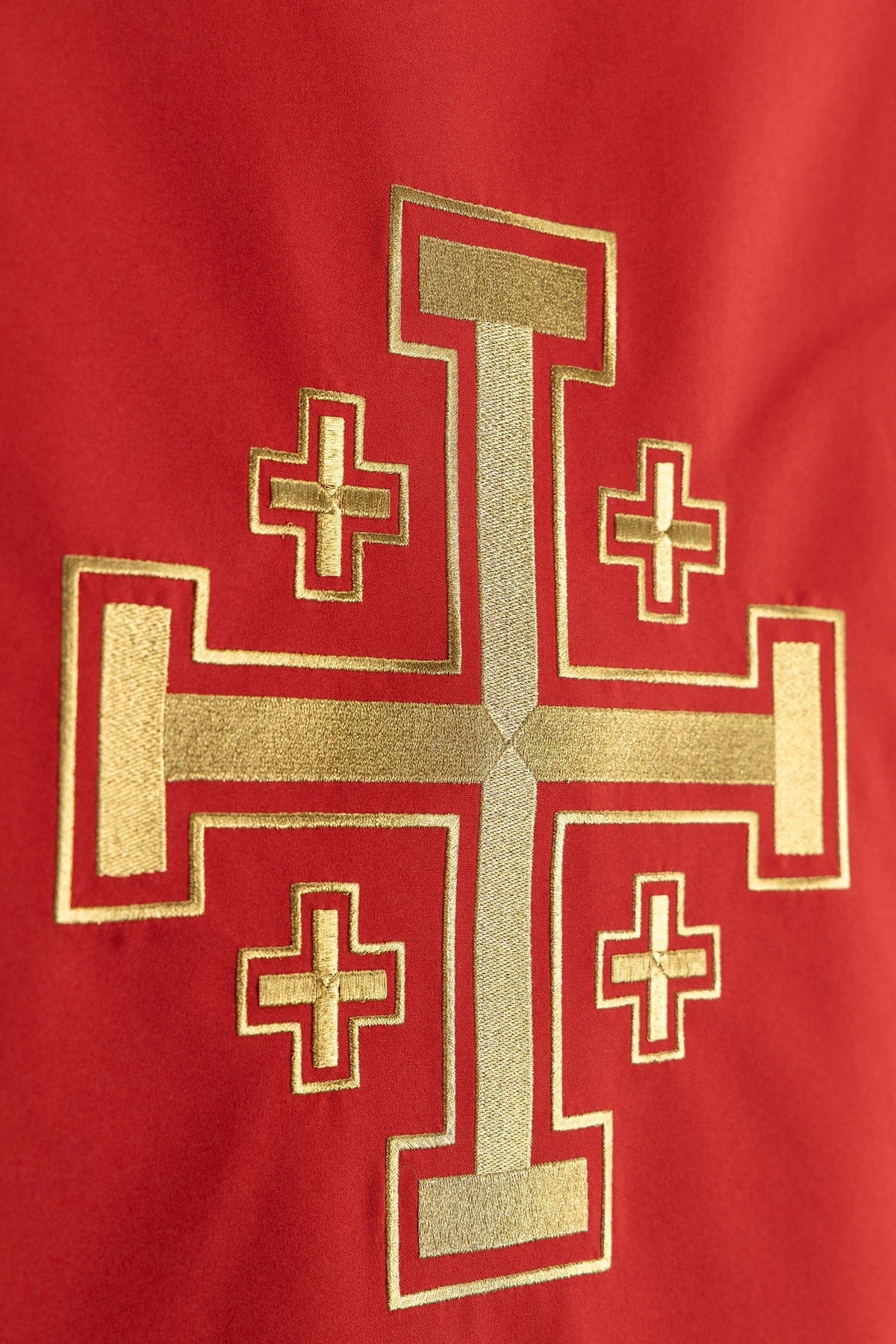 Church lectern cover close-up showing gold Jerusalem cross embroidery on red fabric