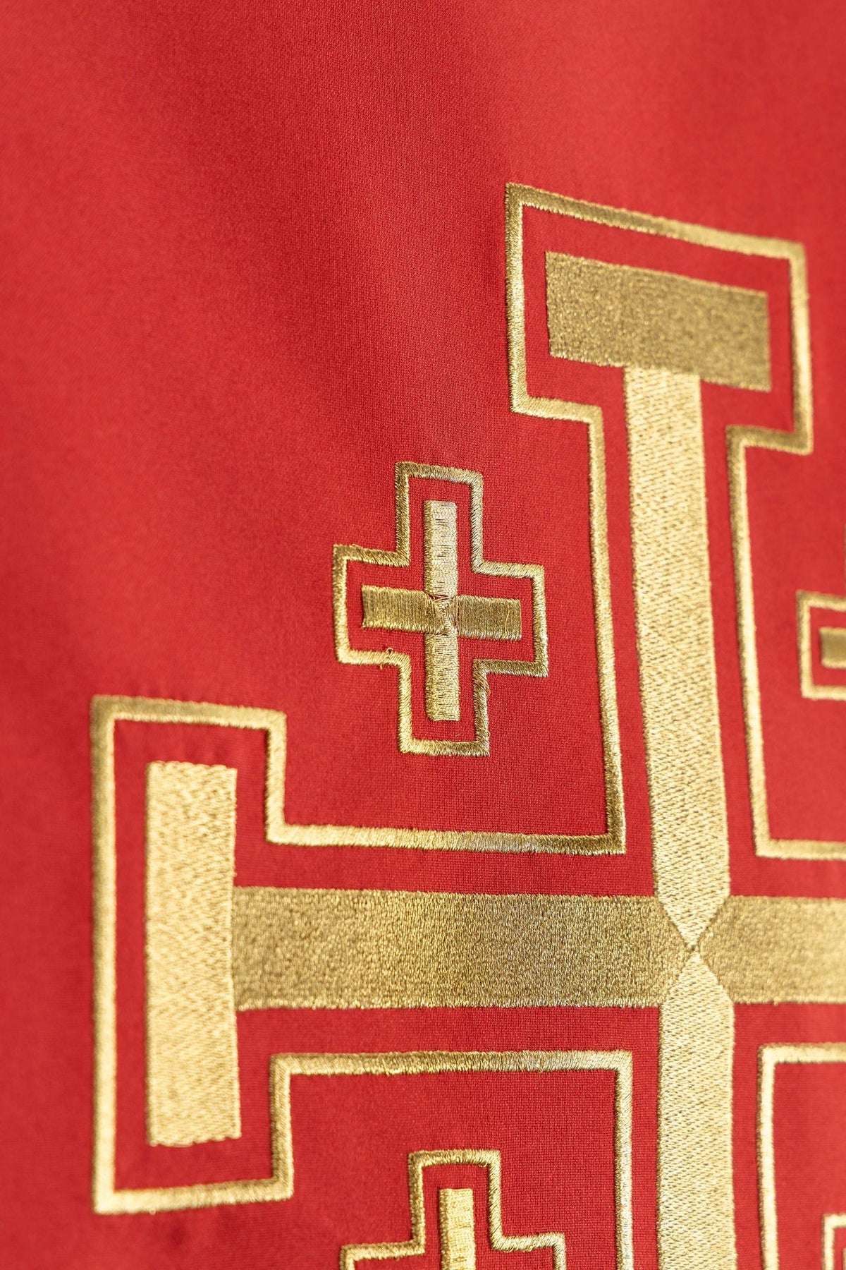 Red church lectern cover detail showing part of the Jerusalem cross embroidery