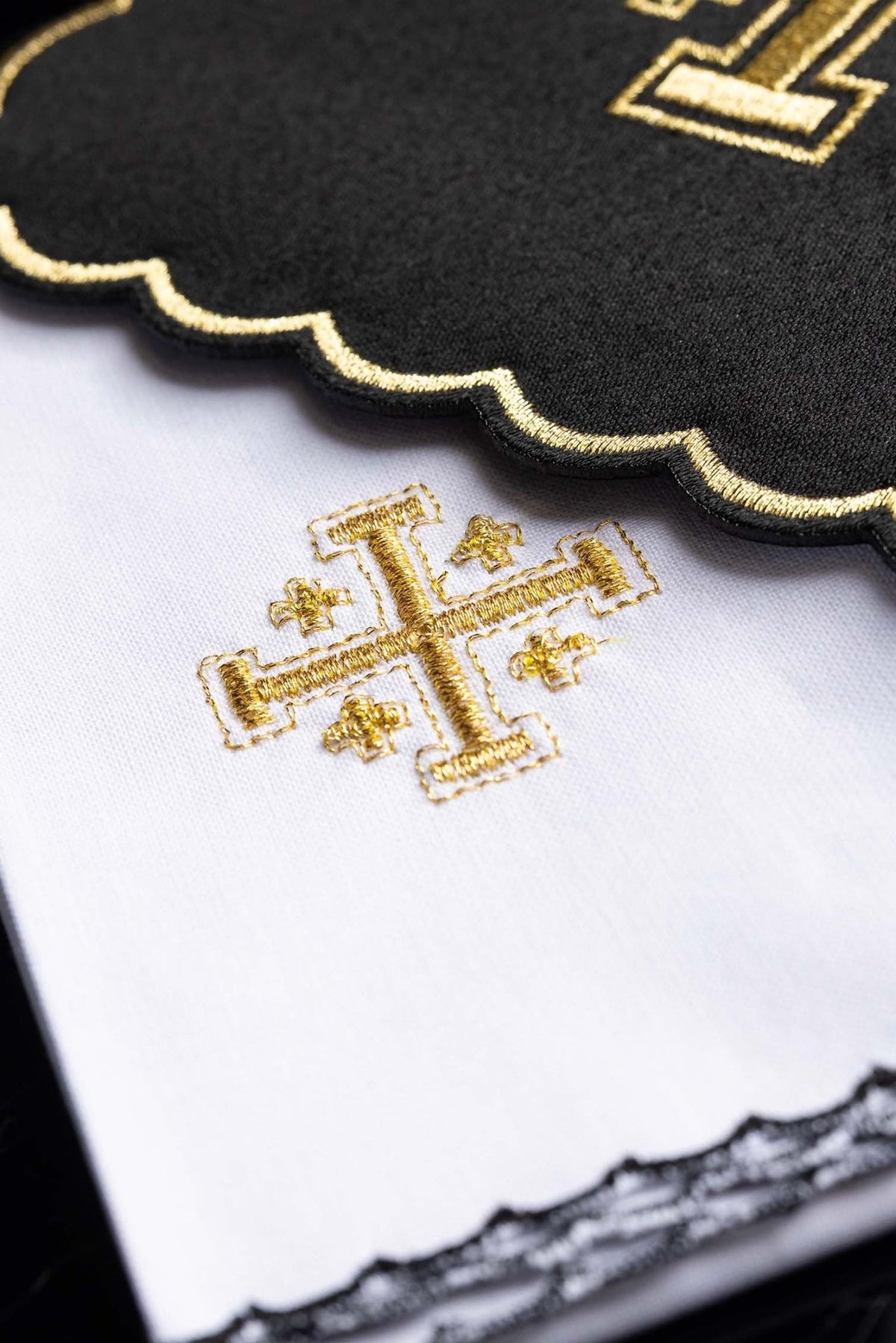 Altar linen set detail showing black cloth, gold embroidery and white linen