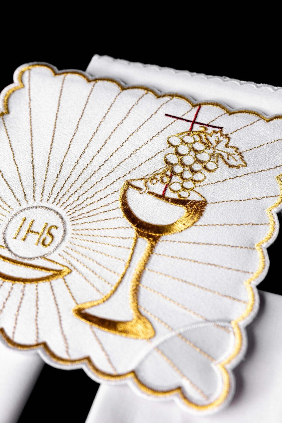 Altar linen set close-up showing embroidered gold chalice, grapes and red cross