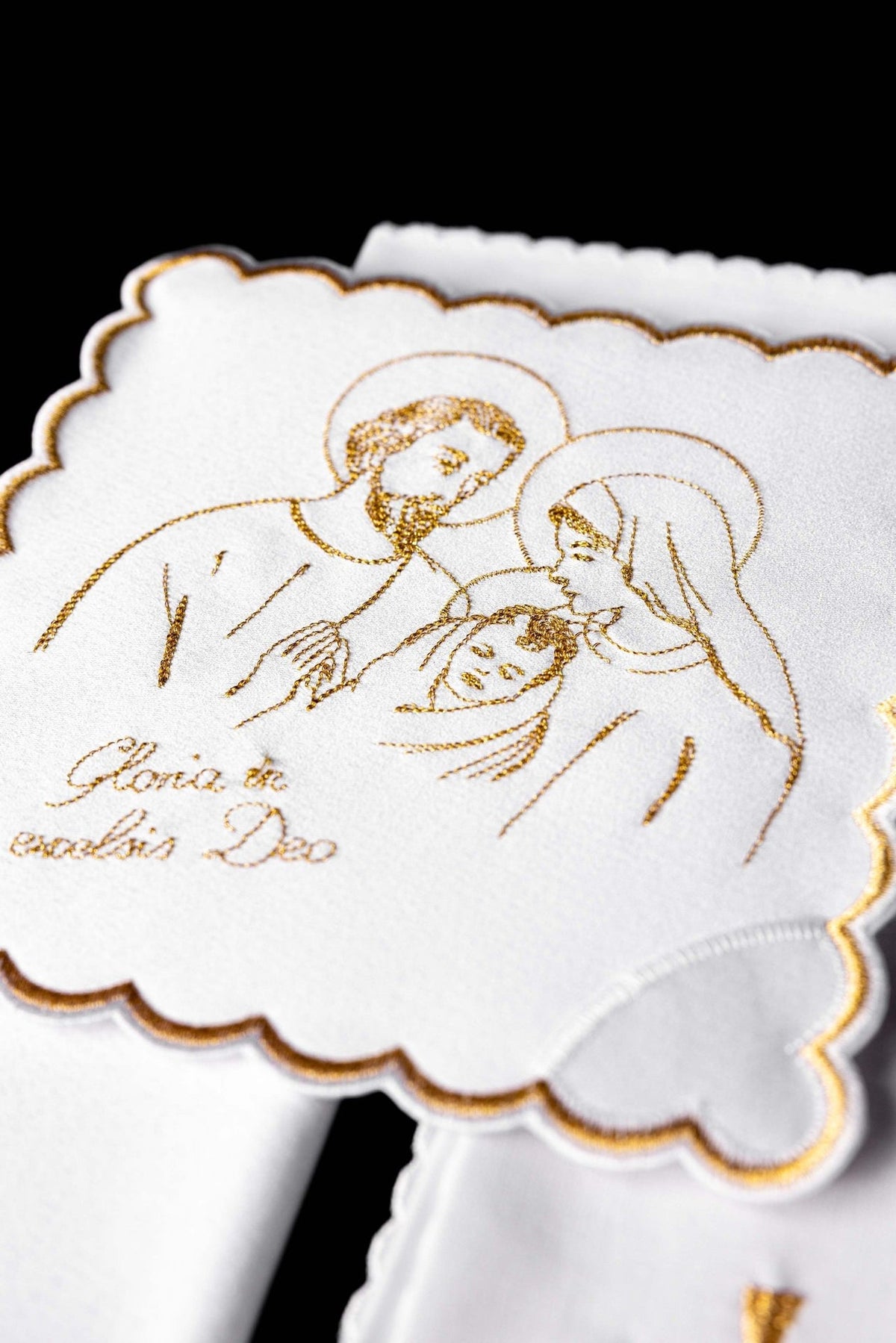 Altar linen set close-up of embroidered gold Holy Family design on white linen