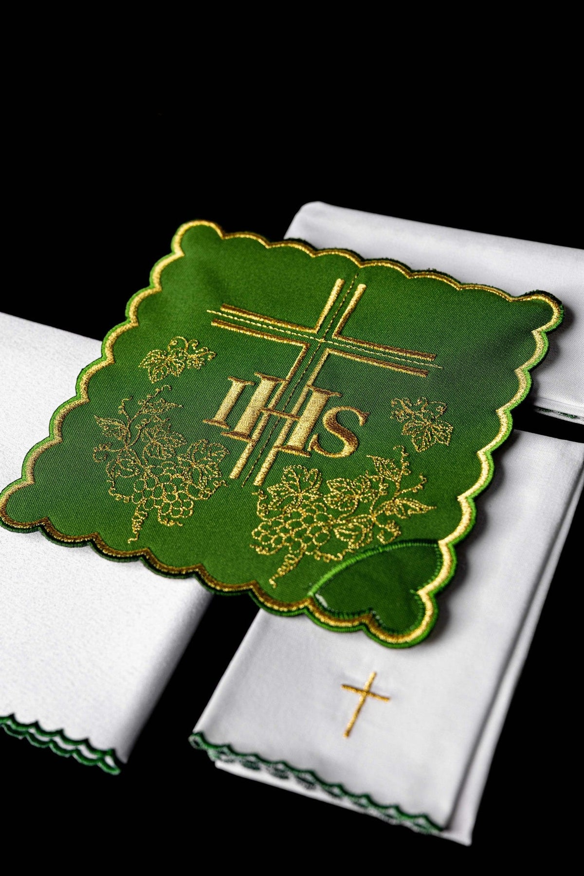 Altar linen set close-up showing green embroidered cloth with gold IHS, cross and grape motifs