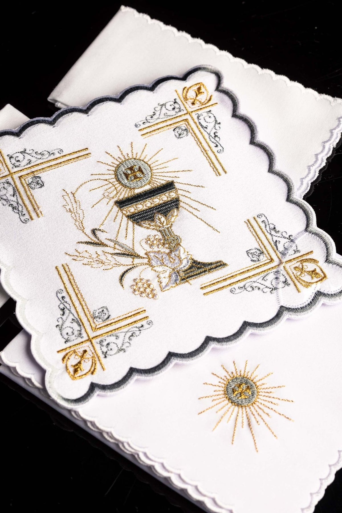 Altar linen set close-up showing central embroidered chalice, grapes, wheat and scalloped edging