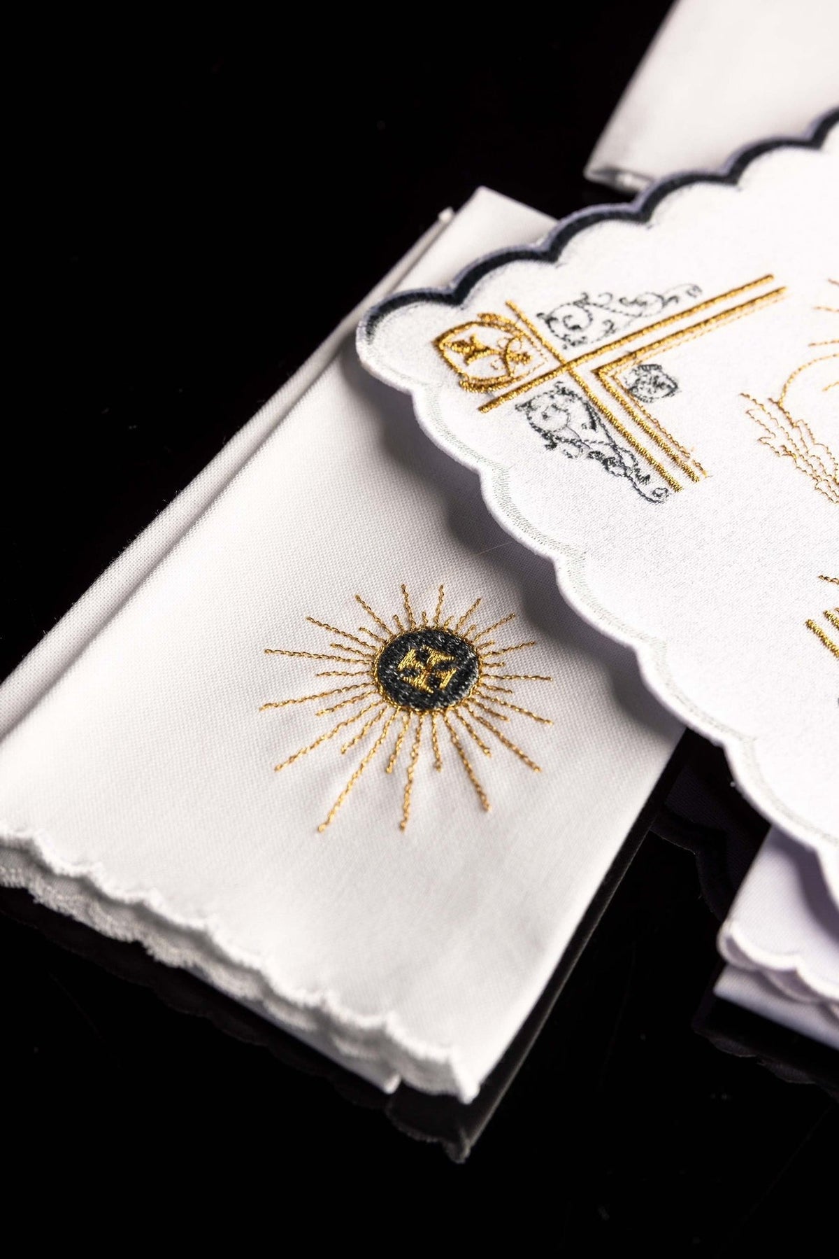 Altar linen set close-up showing gold sunburst embroidery on white fabric with scalloped edge
