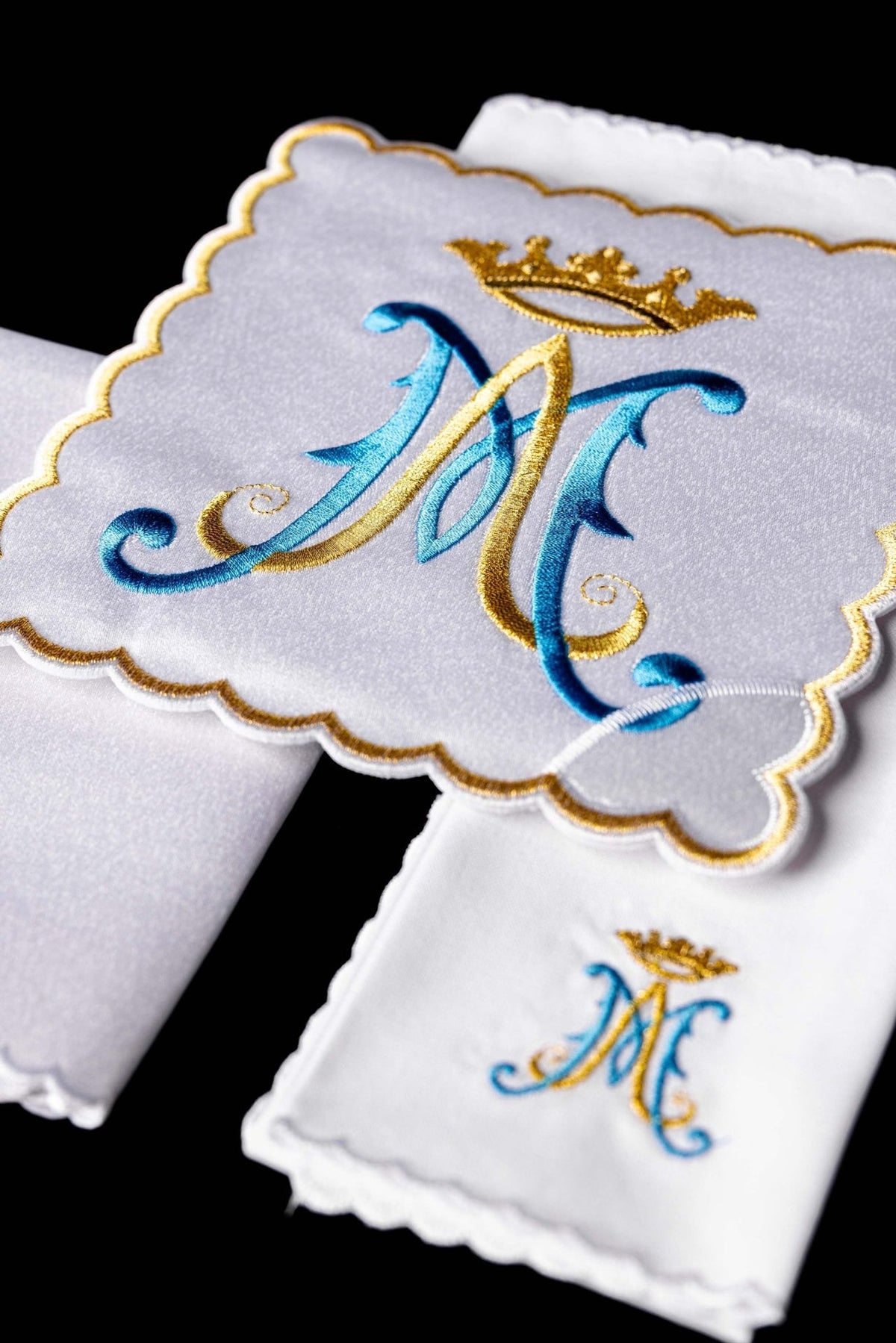 Altar linen set close-up showing a blue and gold Marian symbol with crown