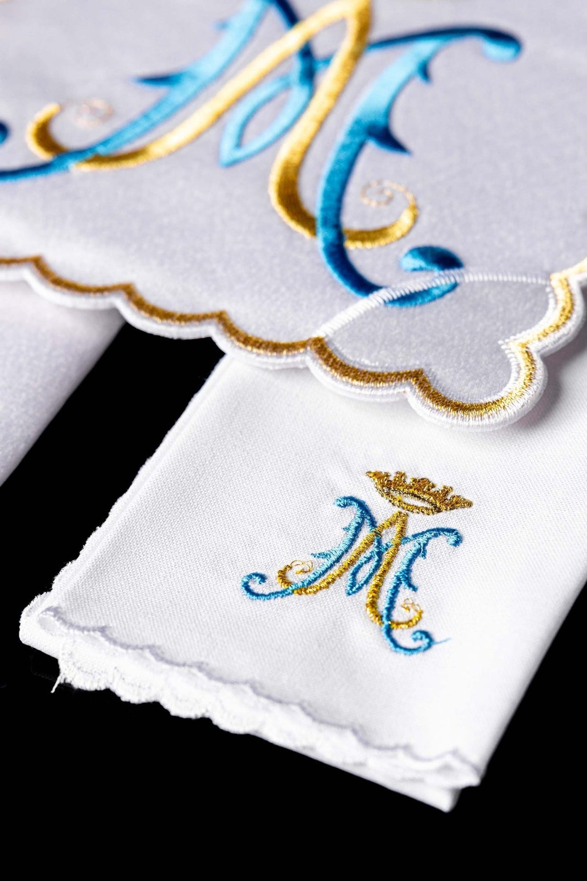 Altar linen set detail showing embroidered Marian symbol and scalloped gold edging