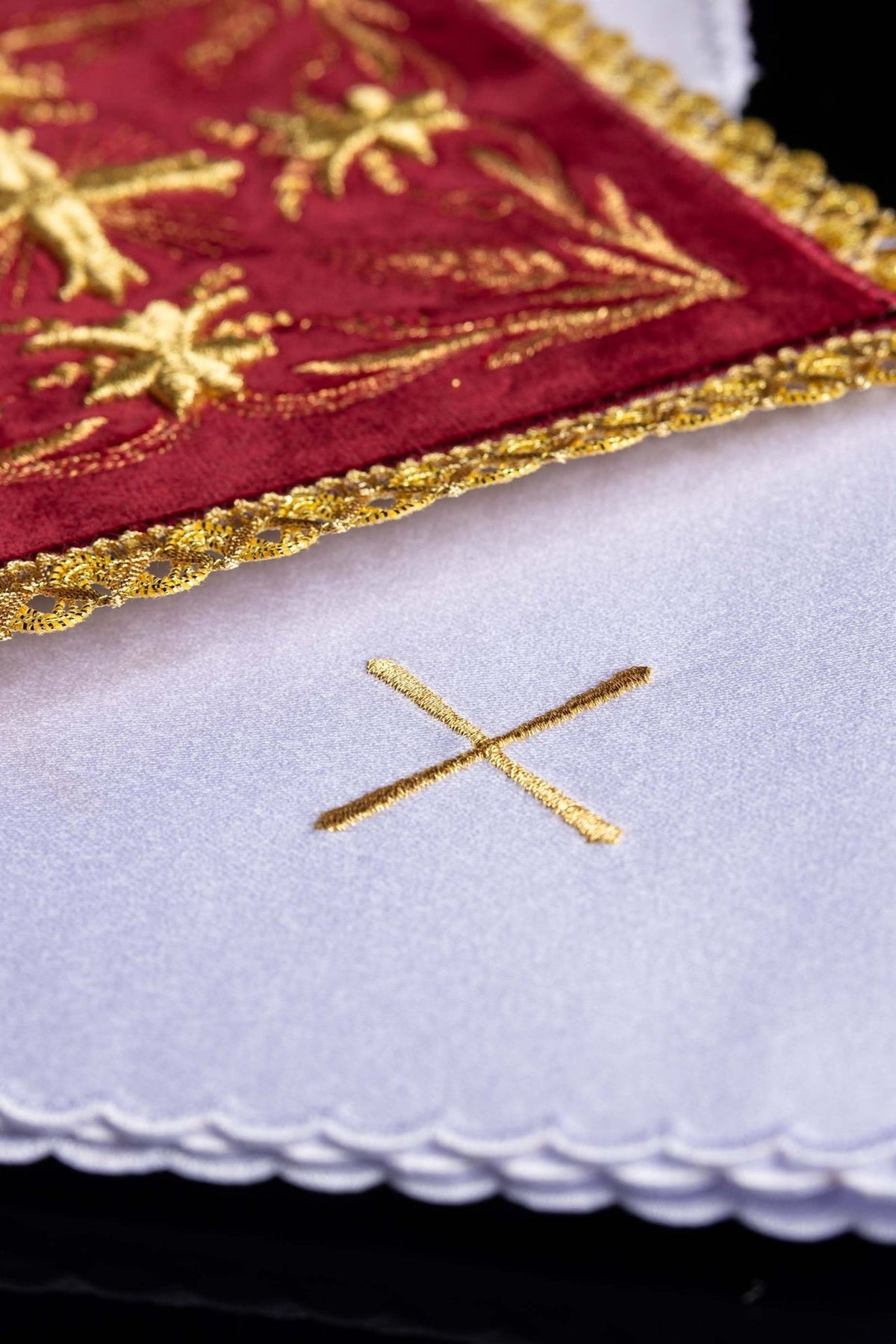 Altar linen set detail showing gold cross embroidery on white linen and red velvet trim