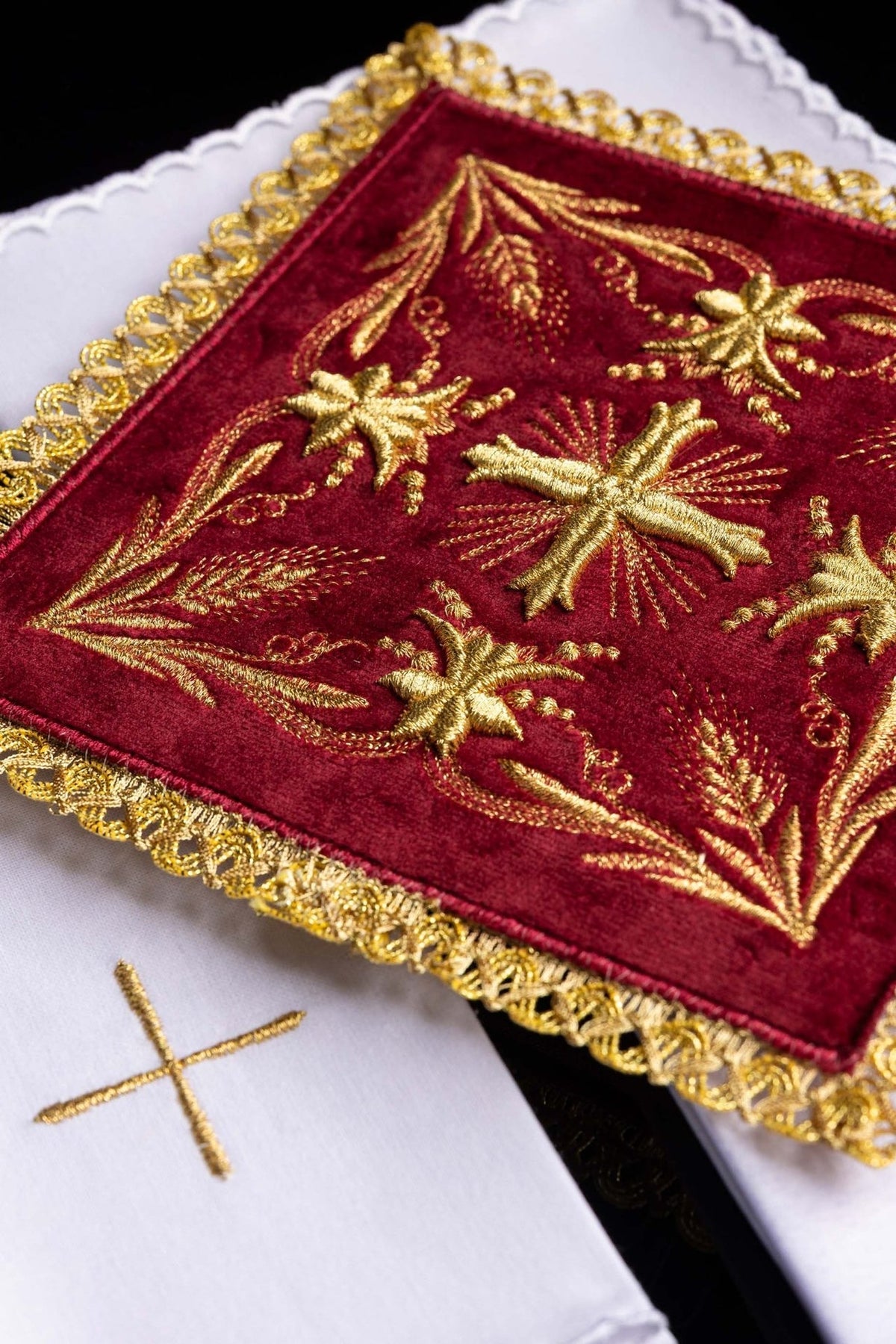 Altar linen set close-up showing red velvet embroidery, floral motifs and gold trim