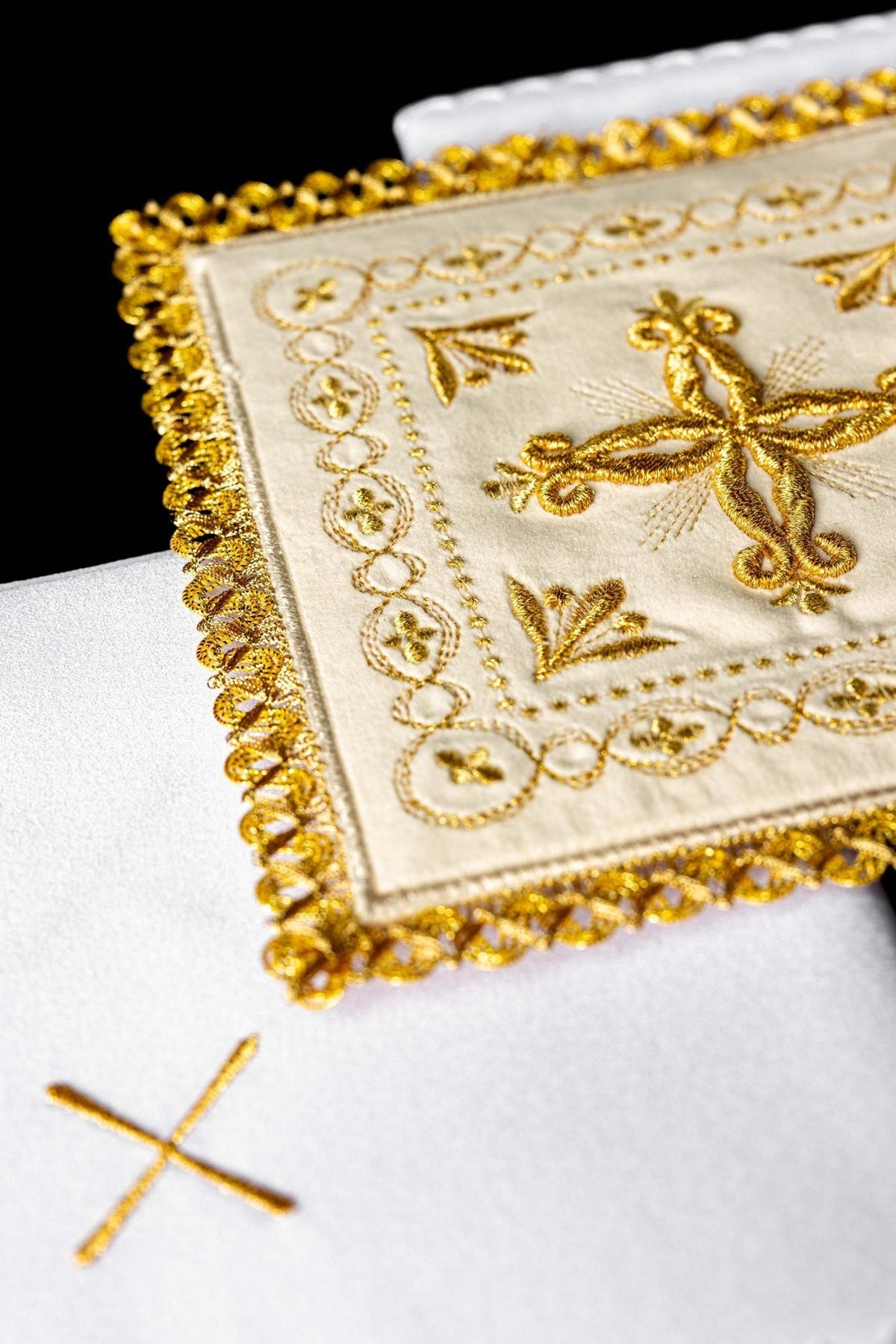 Altar linen set detail showing embroidered cross and ornate gold trim
