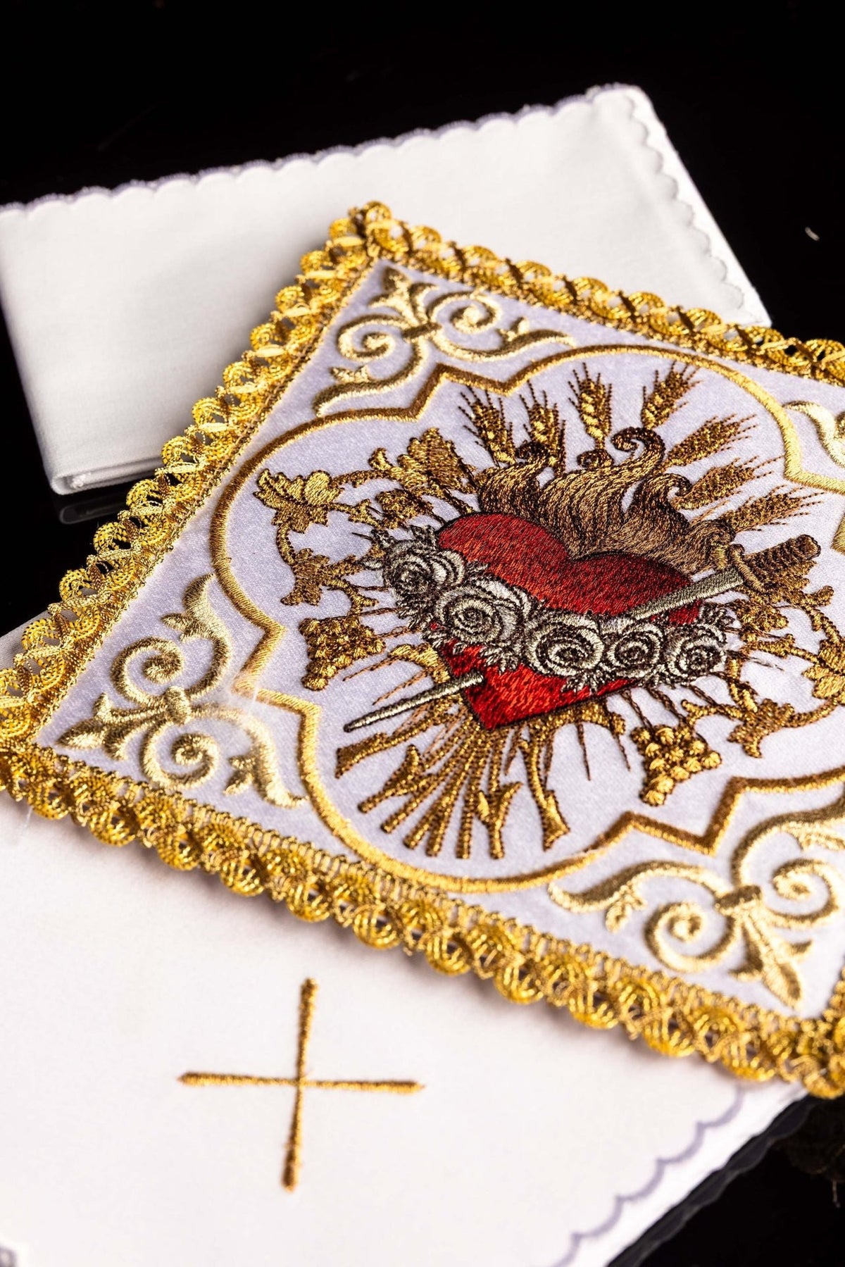 Altar linen set detail showing the embroidered Heart of Mary and gold cross on white linen
