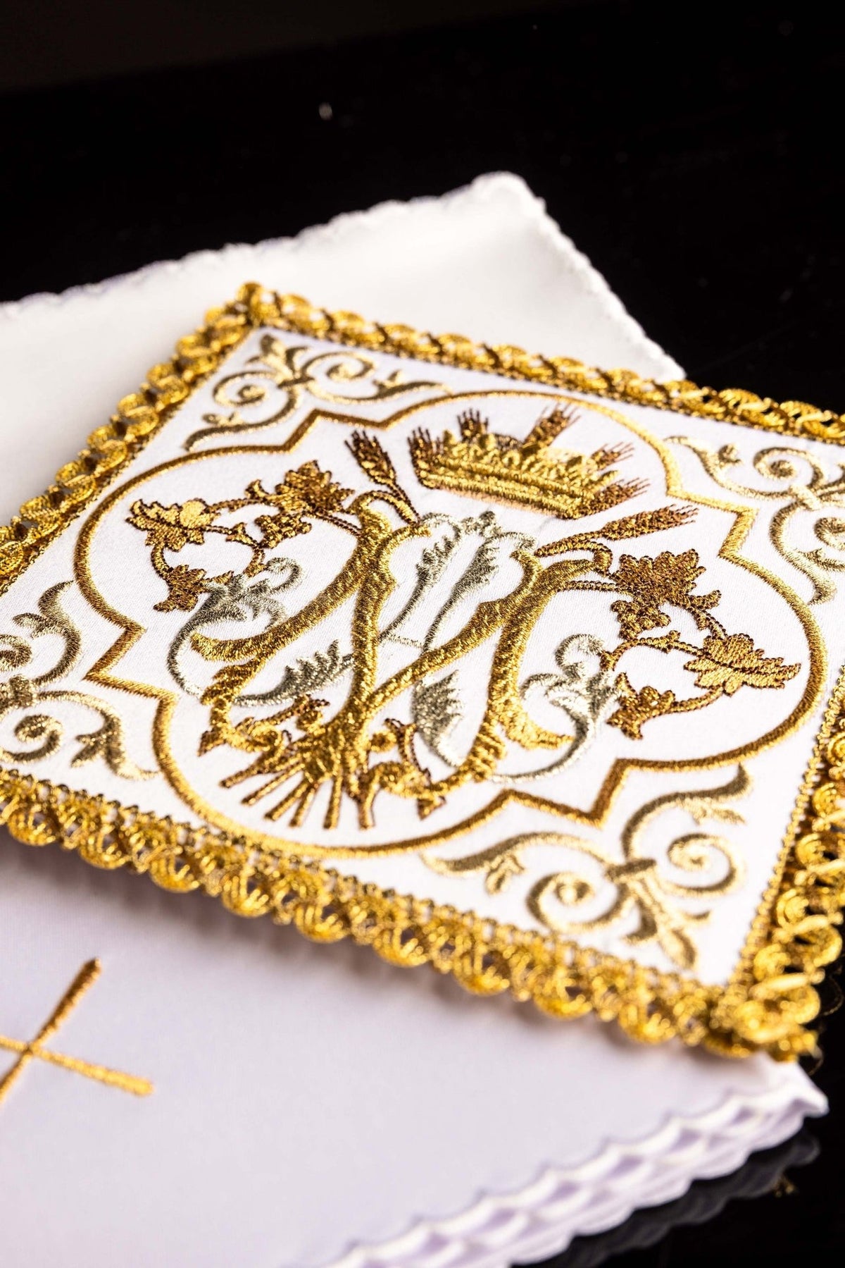 Altar linen set close-up showing gold embroidered Marian symbol and decorative trim