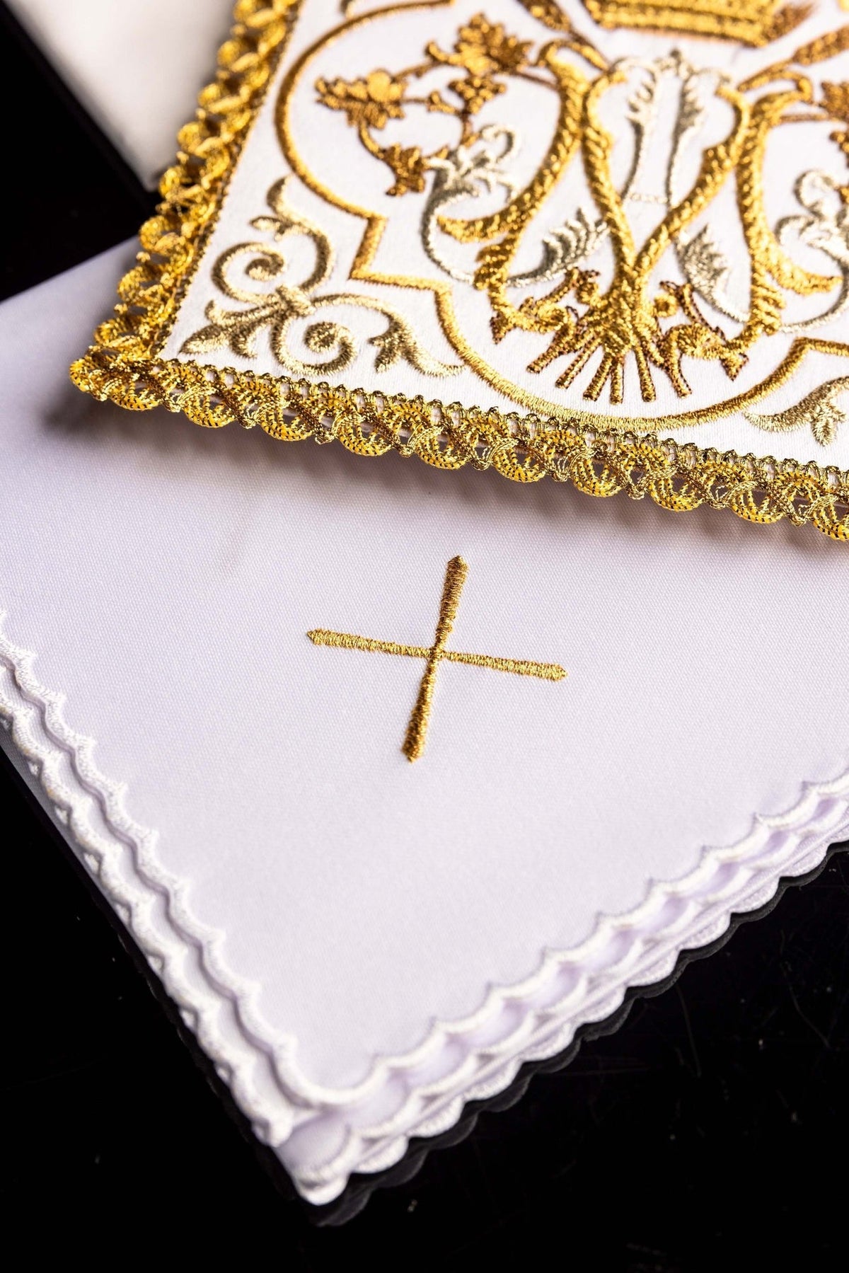 Altar linen set detail showing gold embroidered cross and scalloped white edge