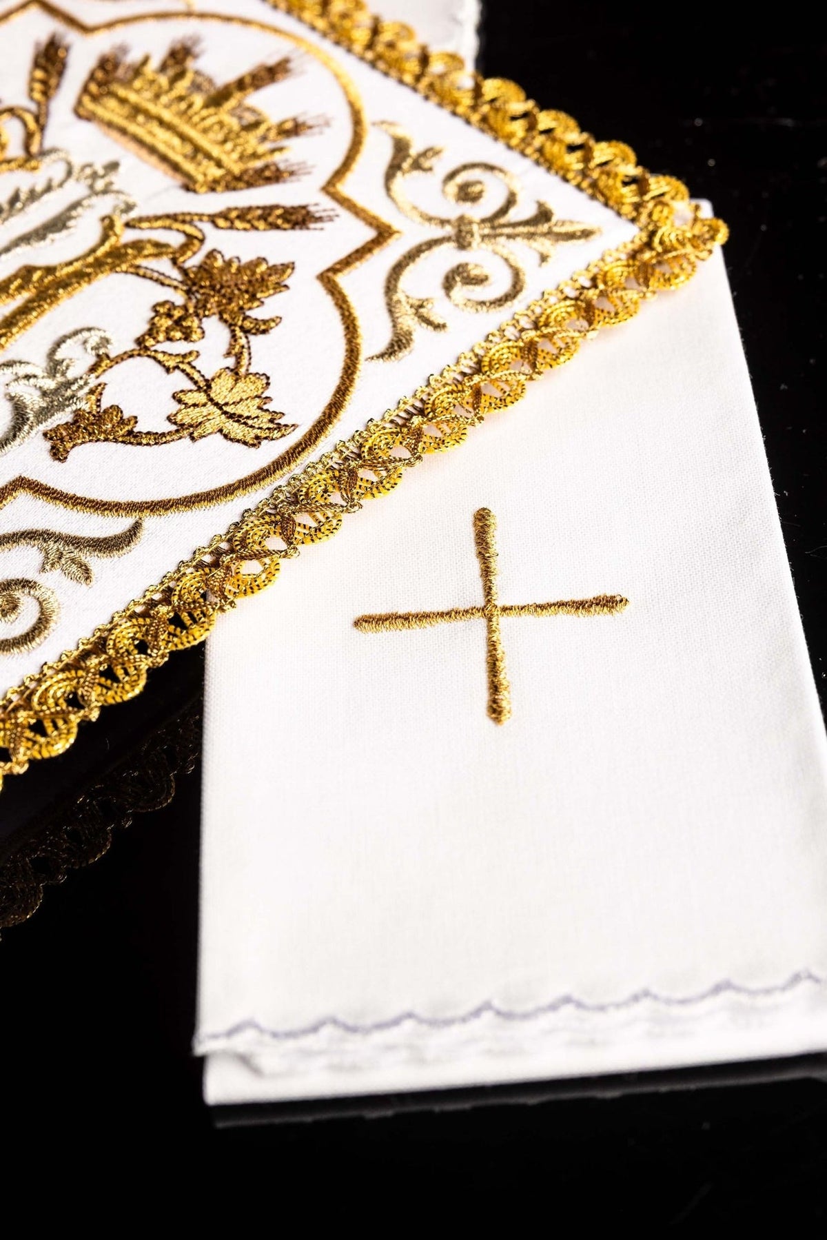 Altar linen set detail showing gold embroidered cross on white linen