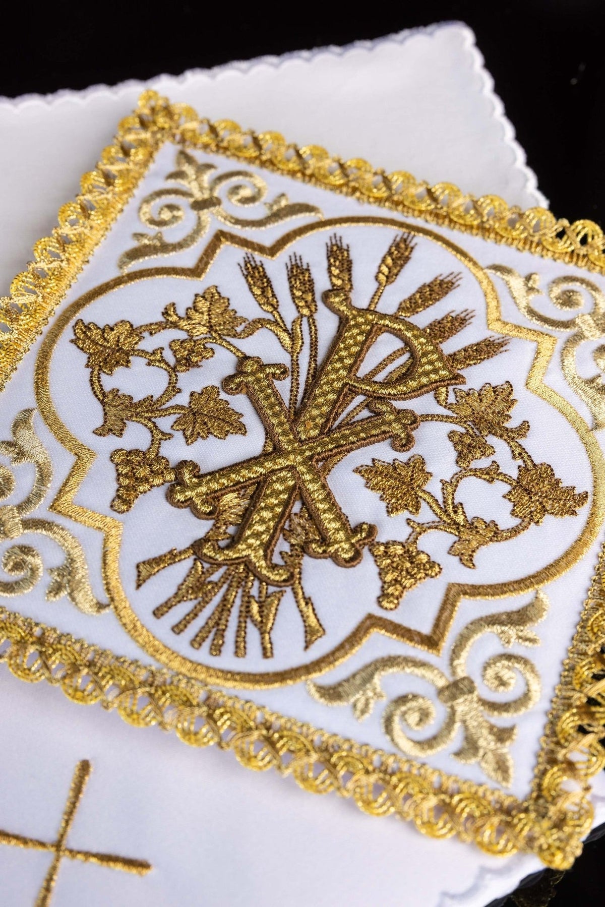 Altar linen set close-up showing embroidered gold PAX symbol with wheat and vine motifs