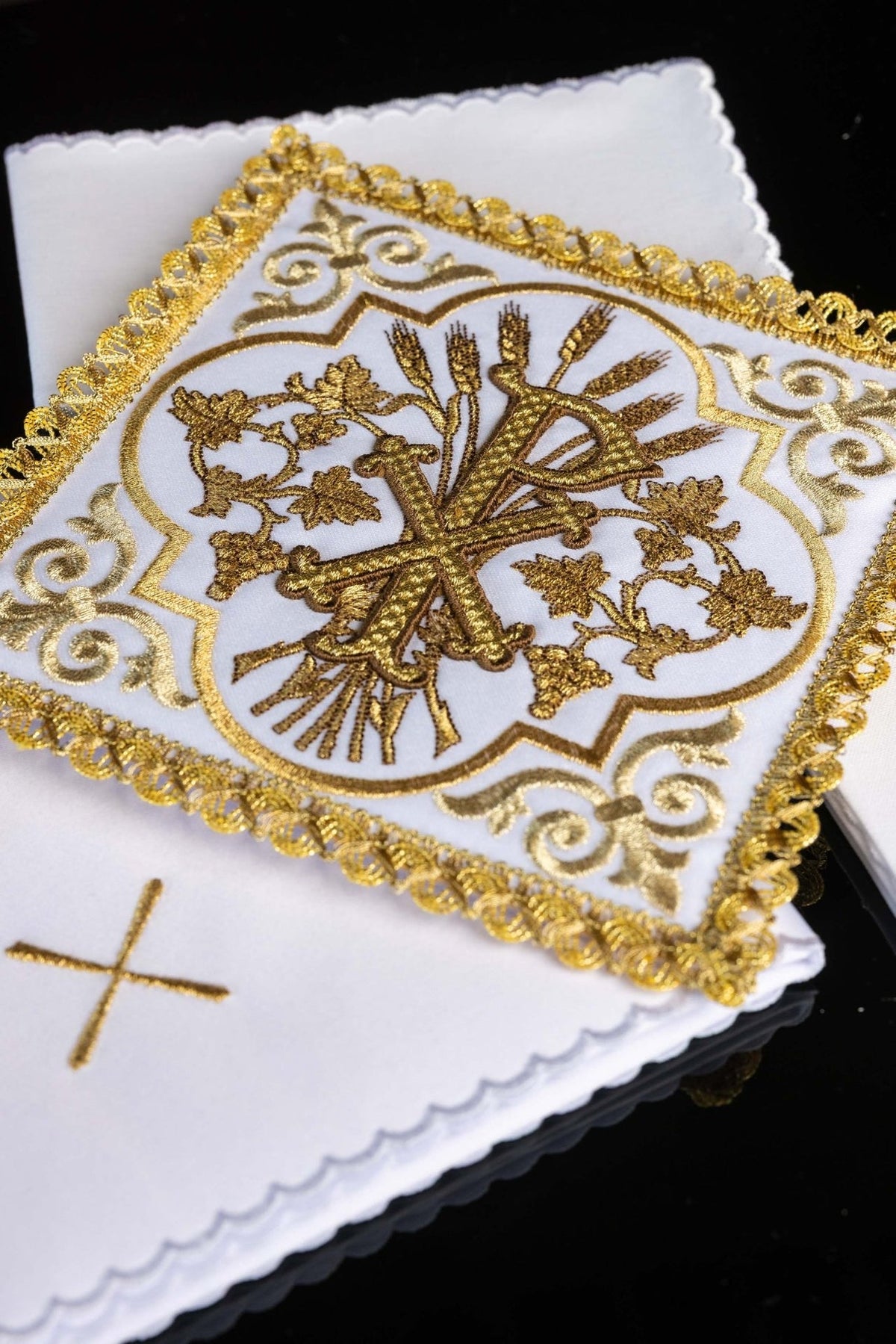 Altar linen set detail showing gold PAX embroidery, wheat and vine motifs, and decorative trim