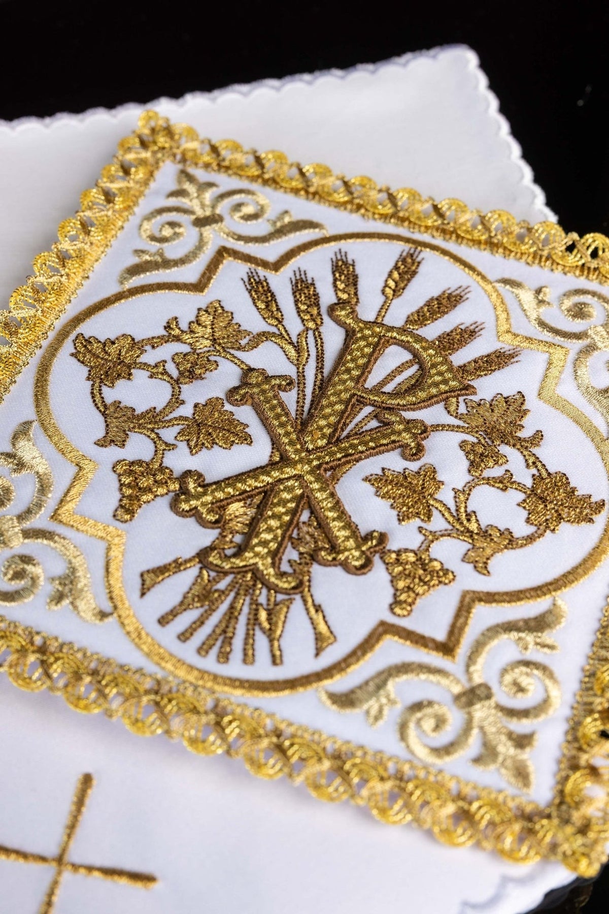 Altar linen set close-up of gold embroidered PAX symbol and scalloped white linen edge