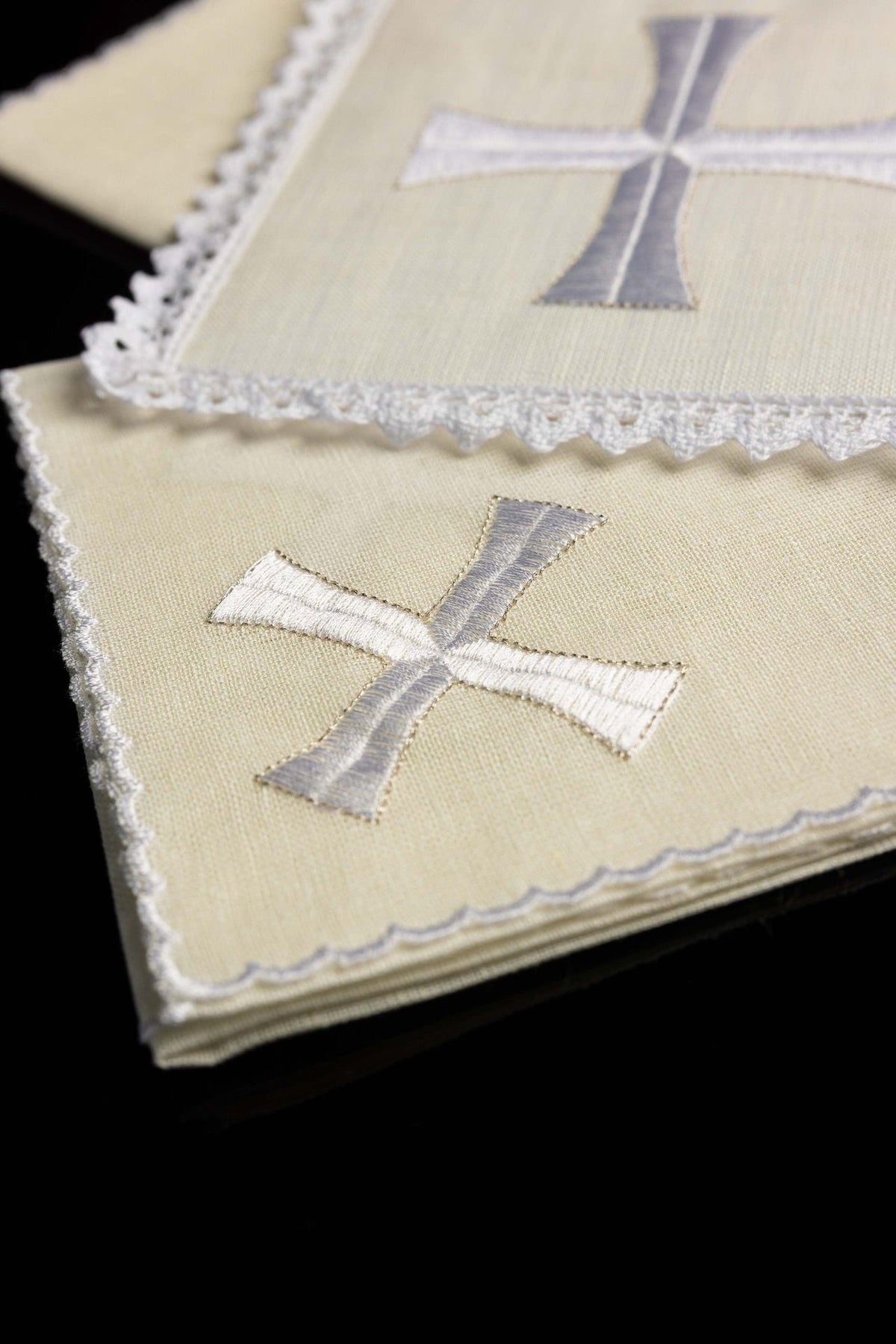 Altar linen set folded, showing ivory linen and silver and white cross embroidery