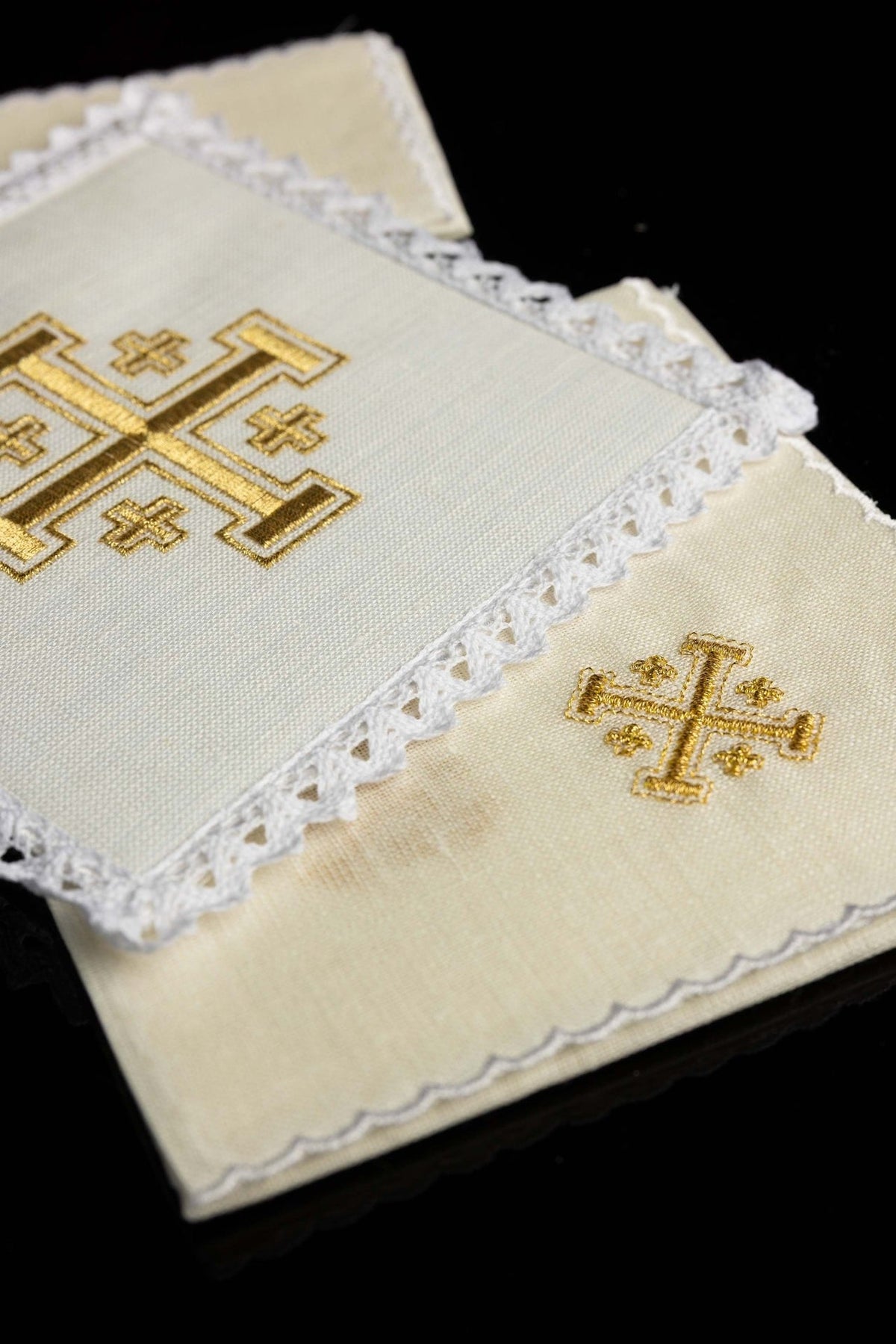 Altar linen set detail showing gold Jerusalem cross embroidery and lace-trimmed ivory linen