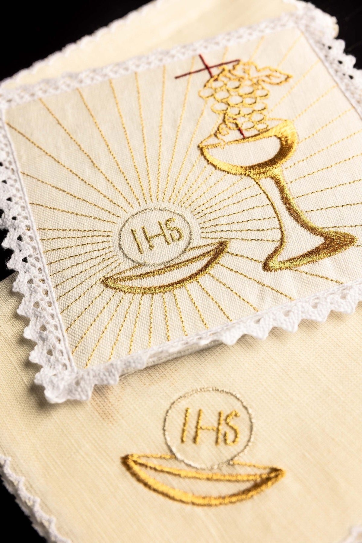 Altar linen set close-up with gold embroidery of a chalice, grapes, cross and radiating lines