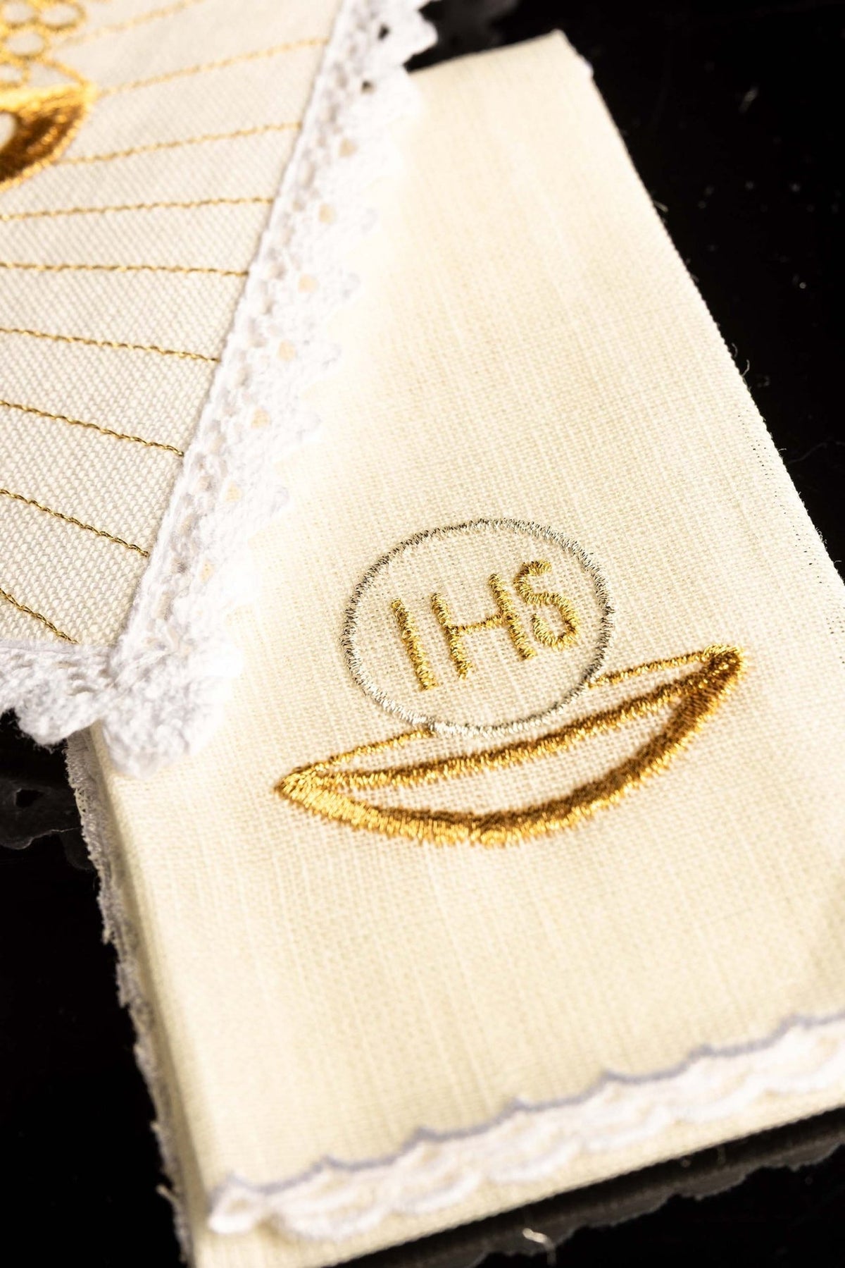Altar linen set detail showing gold embroidered IHS host motif and lace-trimmed linen