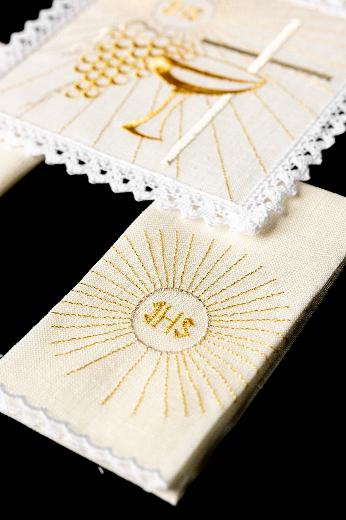 Altar linen set detail showing embroidered gold IHS sunburst and chalice motifs