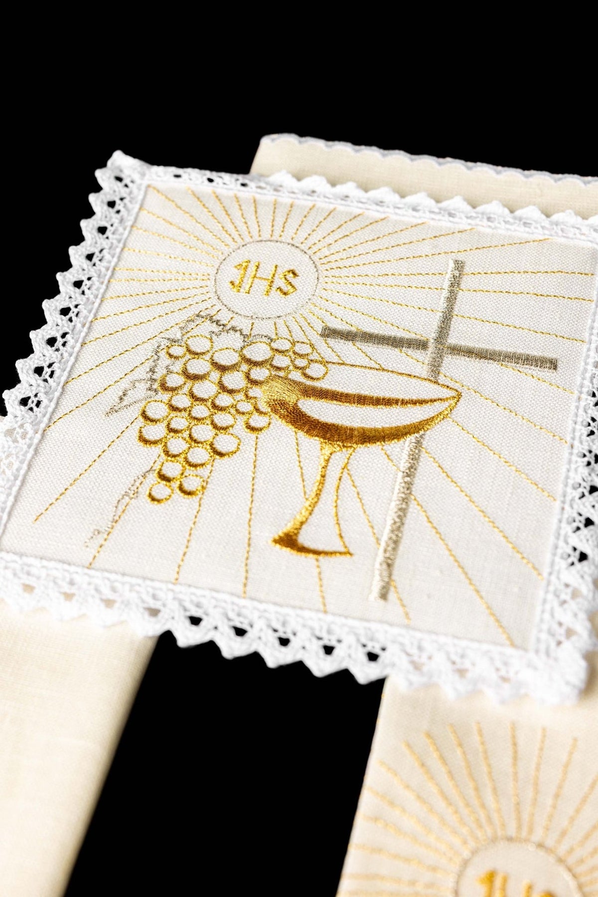 Altar linen set close-up showing embroidered chalice, cross and grape motifs with lace edging
