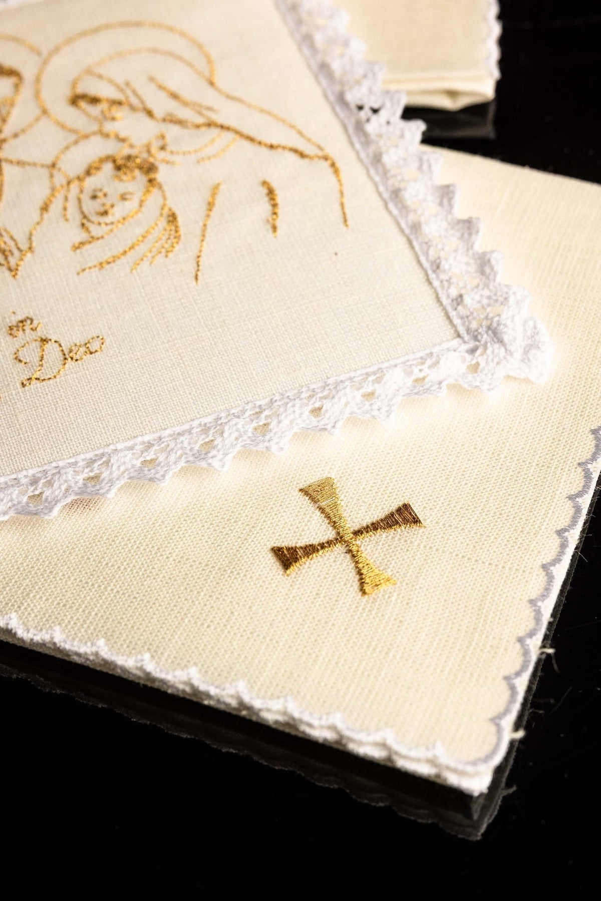 Altar linen set close-up showing a gold embroidered cross and white lace edging