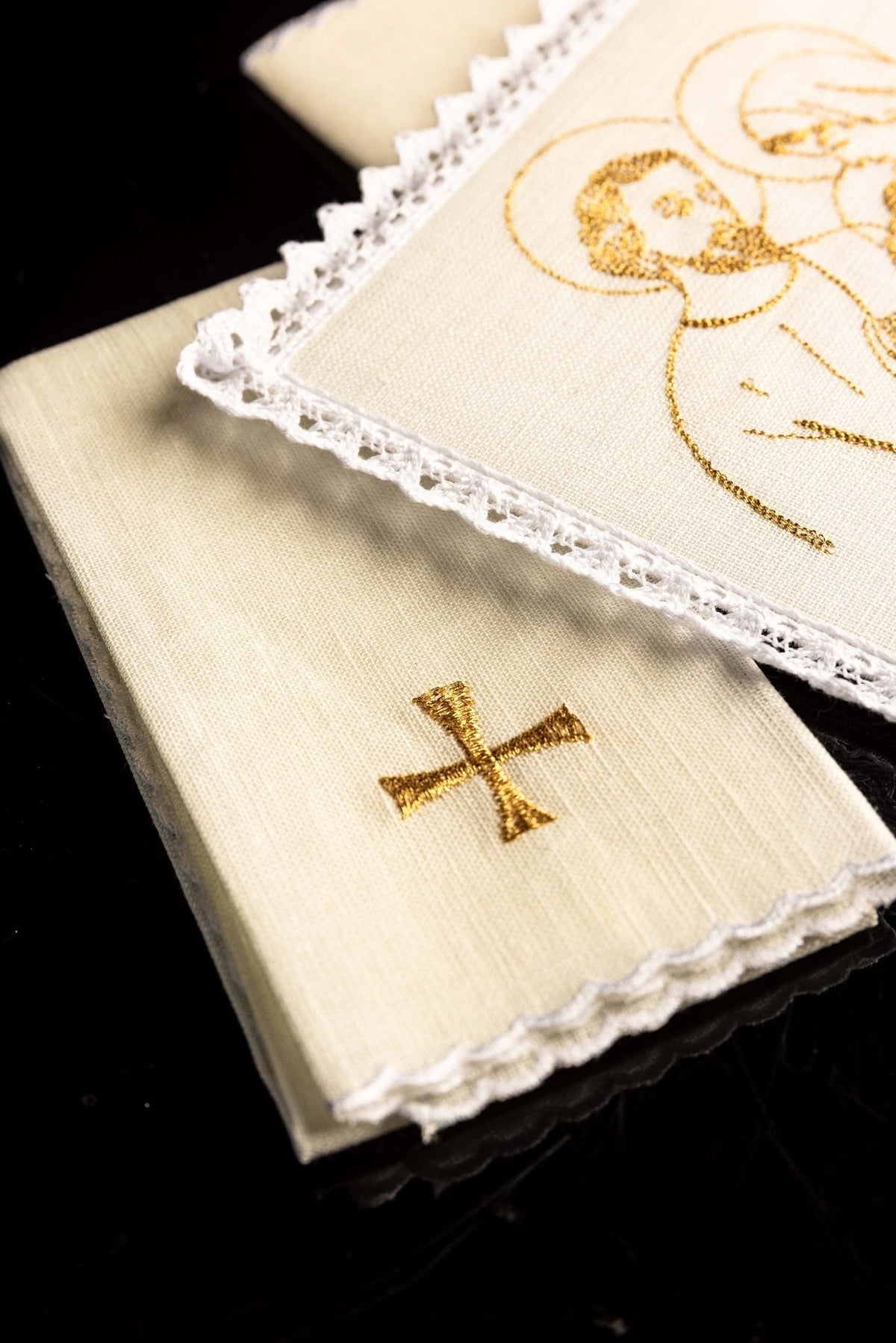 Altar linen set close-up showing white linen fabric, lace edging and gold embroidered cross