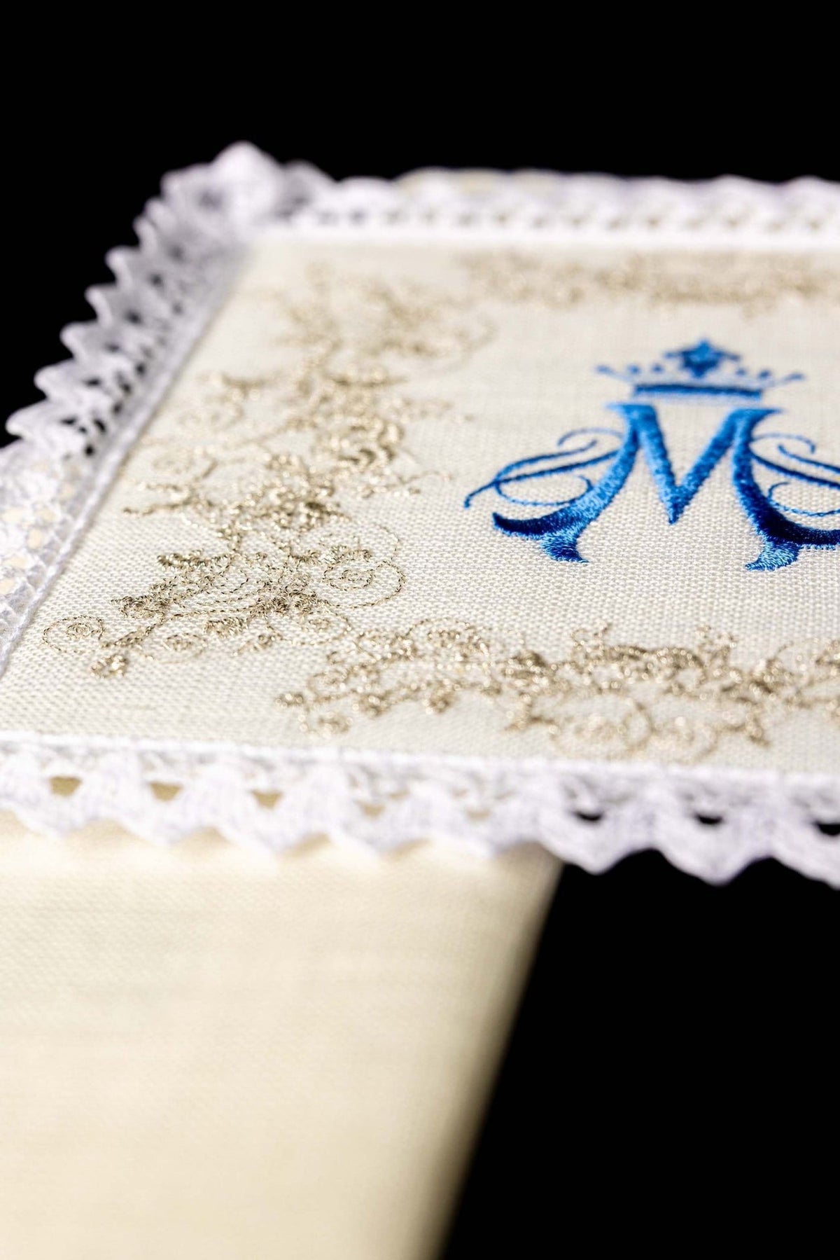 Altar linen set close-up showing gold embroidery, blue Marian symbol and lace trim