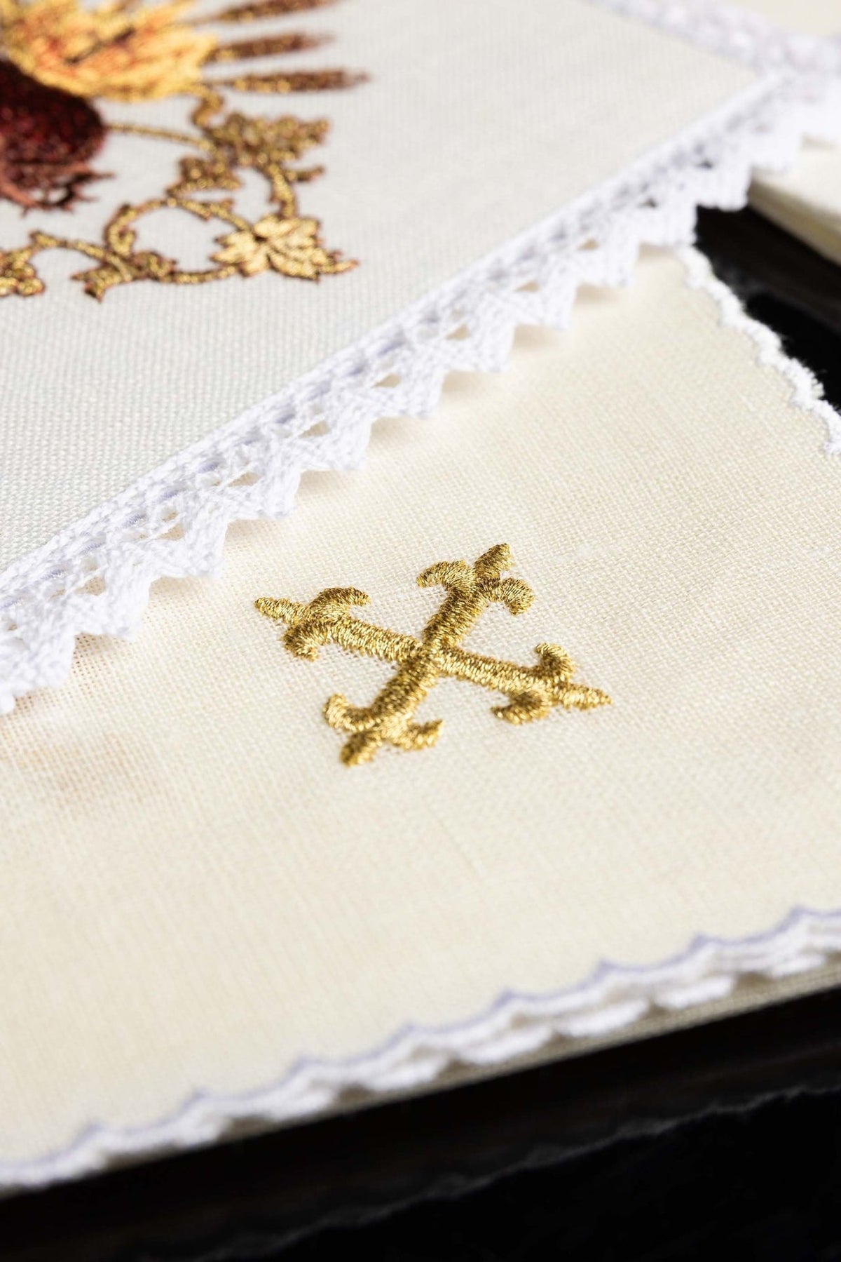 Altar linen set close-up showing a gold embroidered cross on white linen