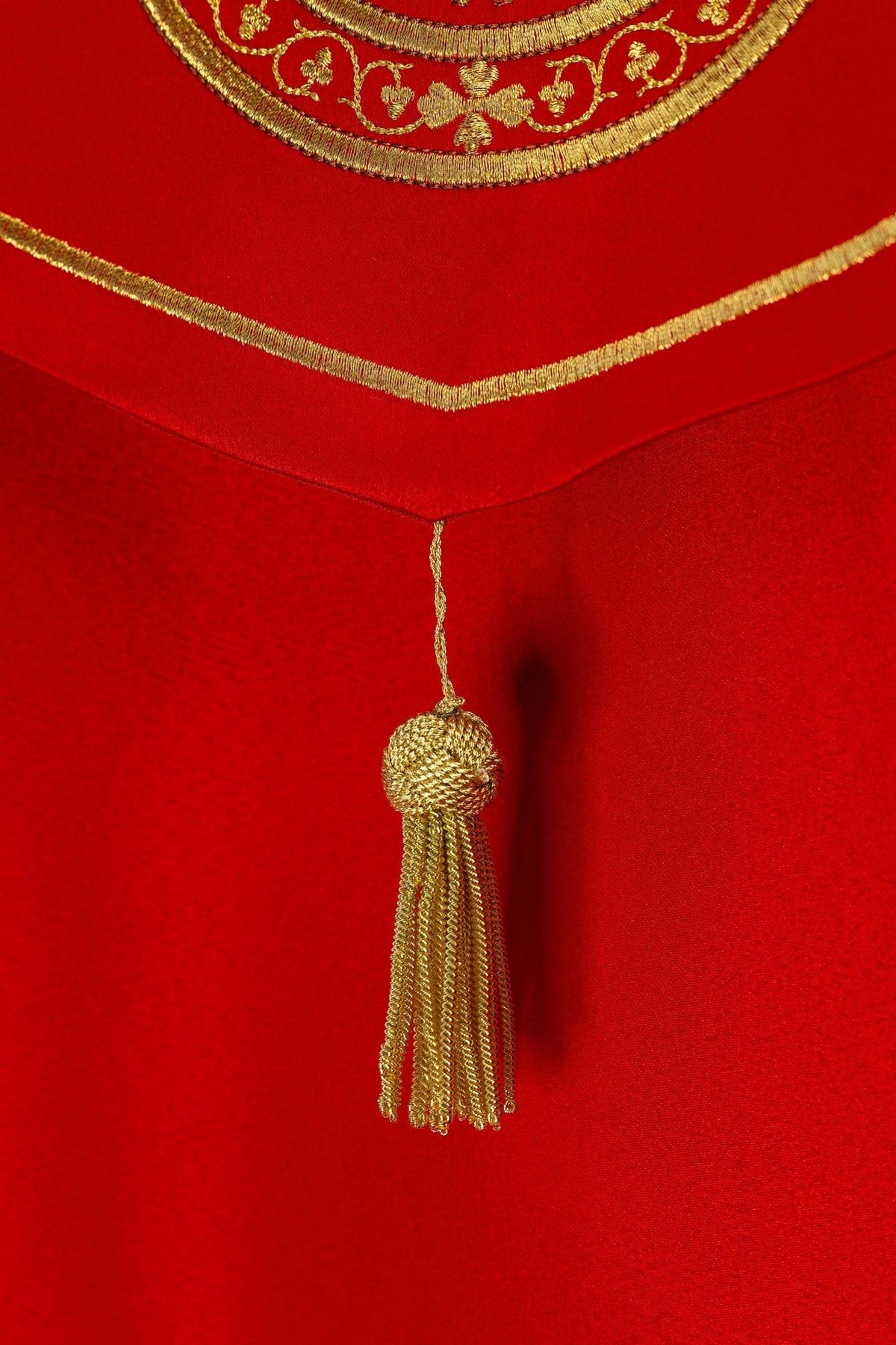 Red liturgical cope back detail with gold embroidered chalice and altar bread