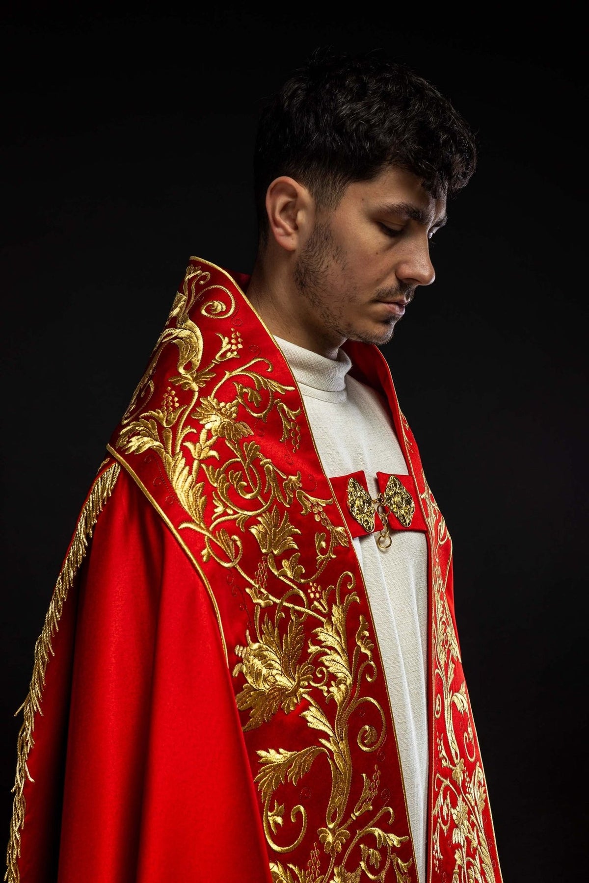 Red satin cope, side view showing gold floral embroidery and red fabric