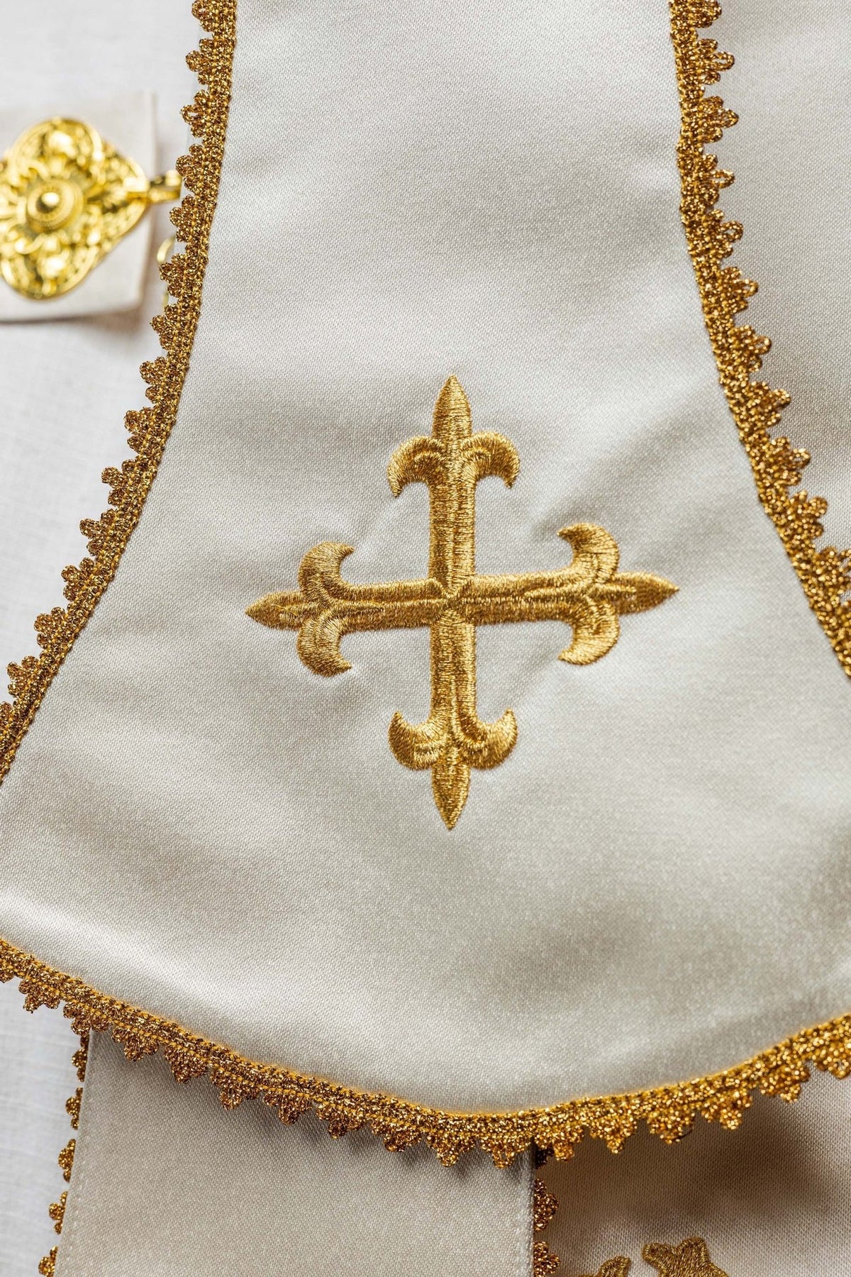 Ecru satin cope, close-up of embroidered gold cross on matching stole