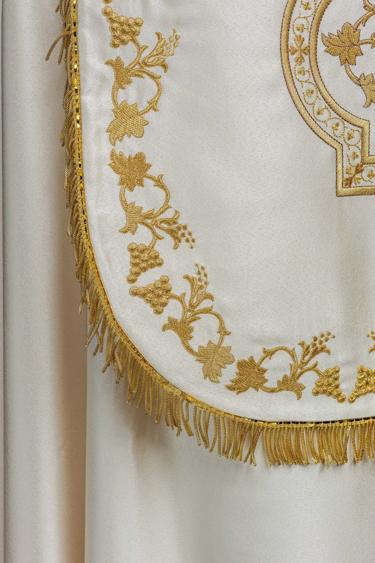 Ecru satin Roman cope detail with gold floral embroidery and fringed edge