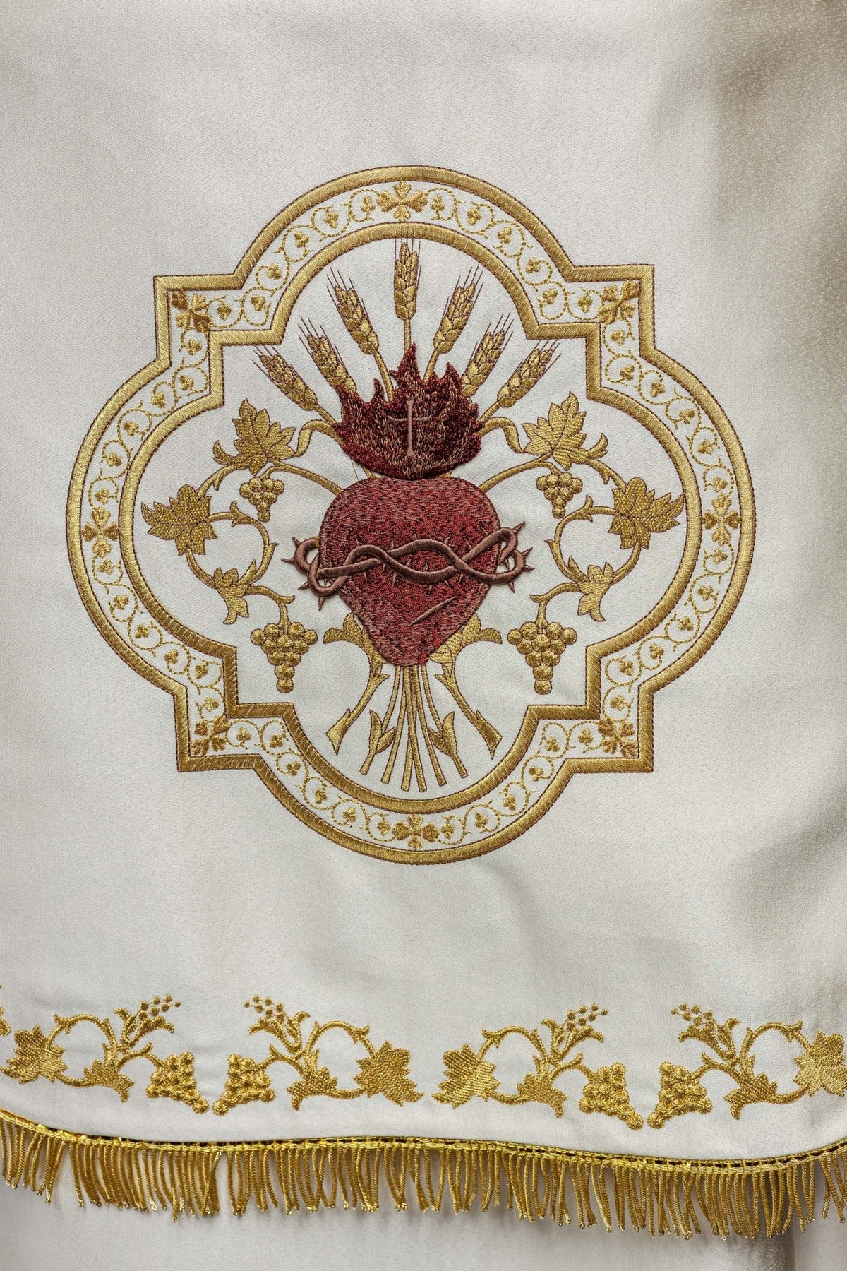 Ecru satin cope, close-up of embroidered Sacred Heart of Jesus and gold fringe