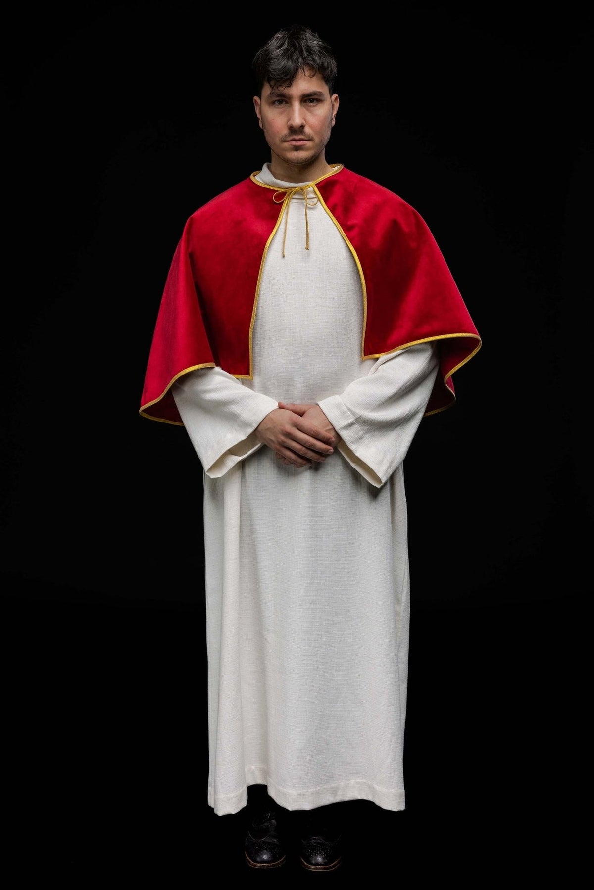 Red altar server cape worn from the front, showing its draped shape and gold trim