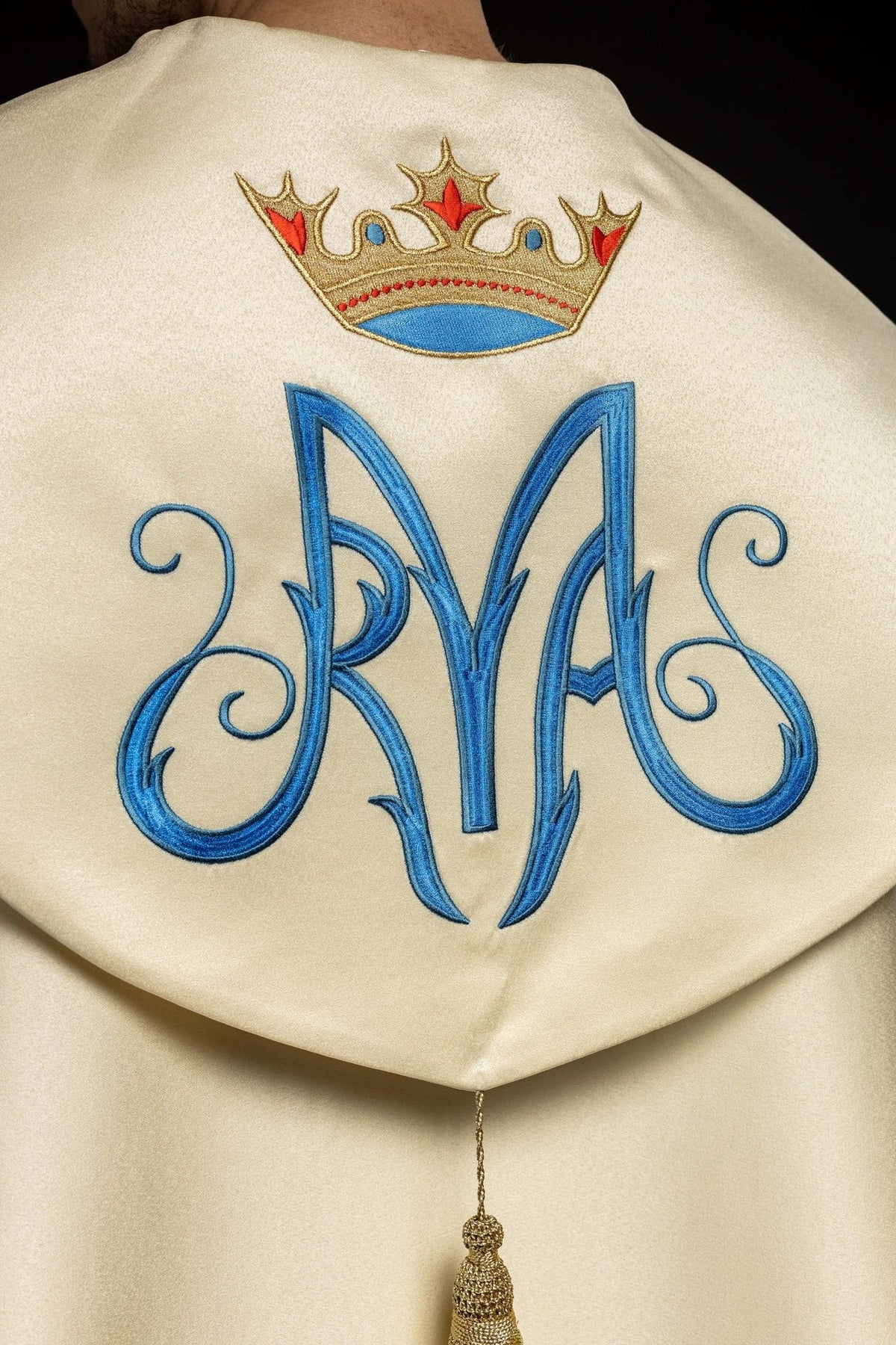 Marian cope back embroidery close-up with blue monogram and crowned emblem