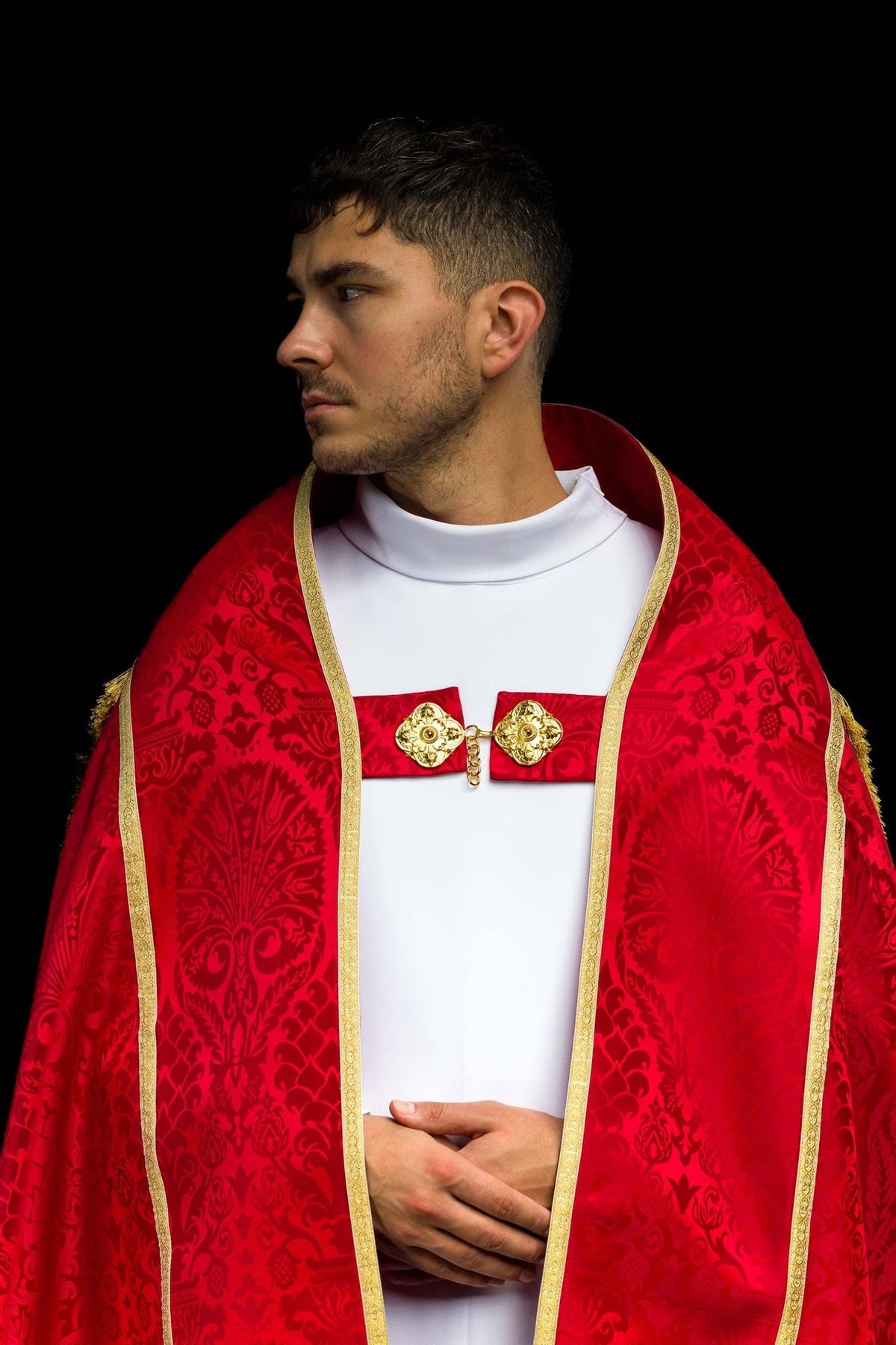 Red cope front close-up showing floral jacquard motifs, gold edging and ornate chest clasp