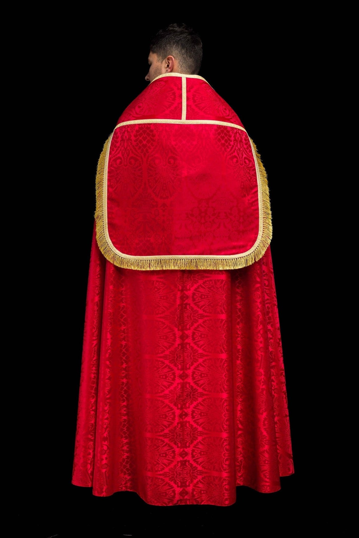 Red Roman cope full back view with patterned jacquard fabric, gold trim and fringe