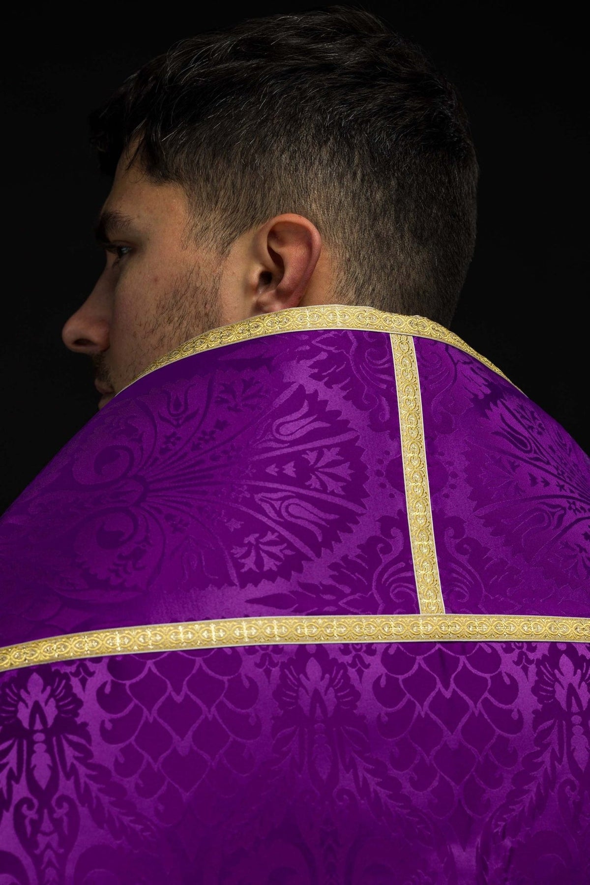 Purple Roman cope detail showing gold trim against patterned jacquard fabric